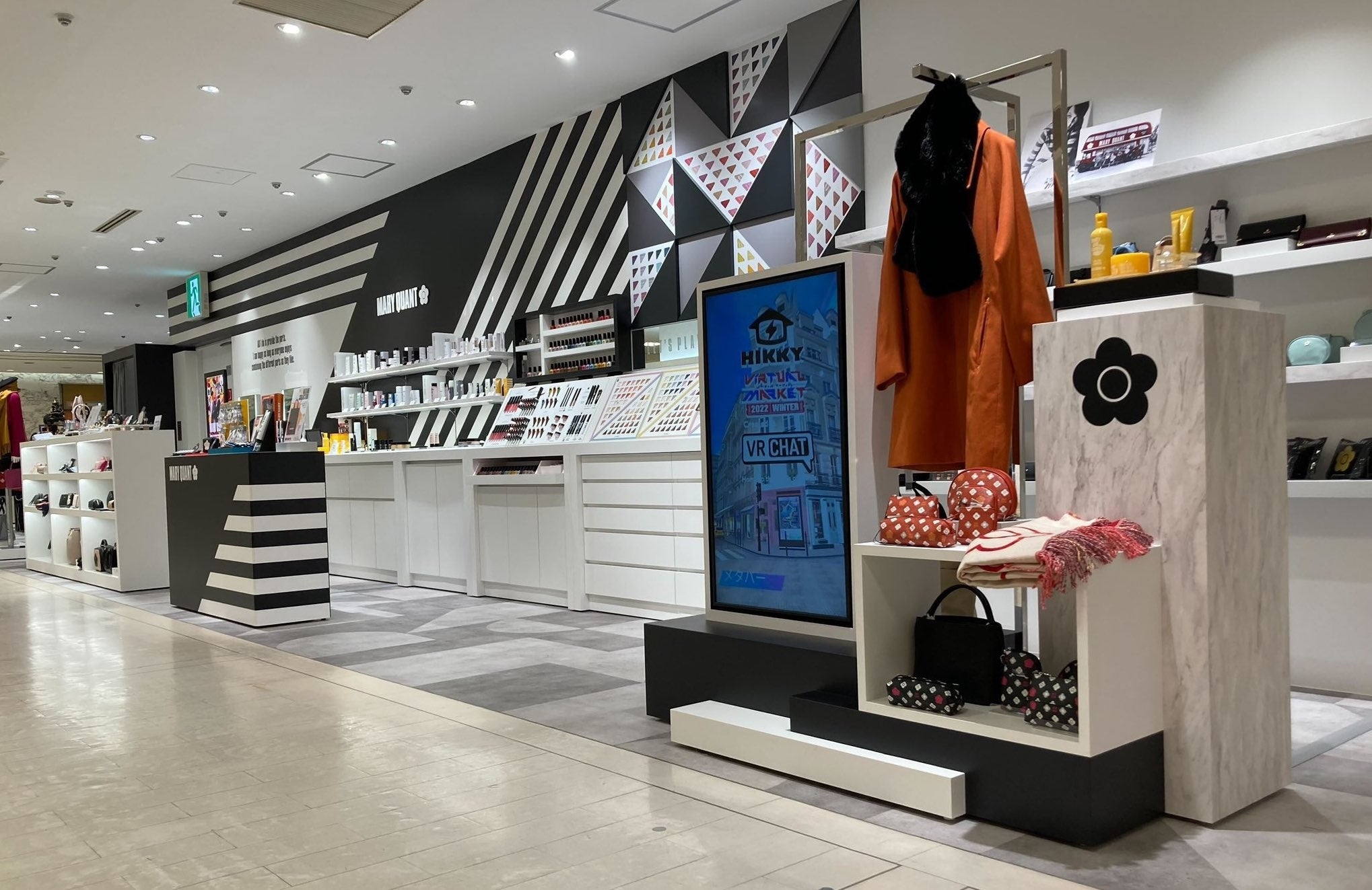 リアル店舗に設置されたデジタルサイネージでバーチャルマーケットの実施内容について紹介が行われた様子