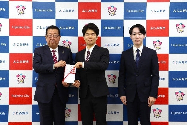 ふじみ野市高畑市長（写真左）に手渡しをする マッスルプロジェクト代表学生の２名(中央が栗山さん)