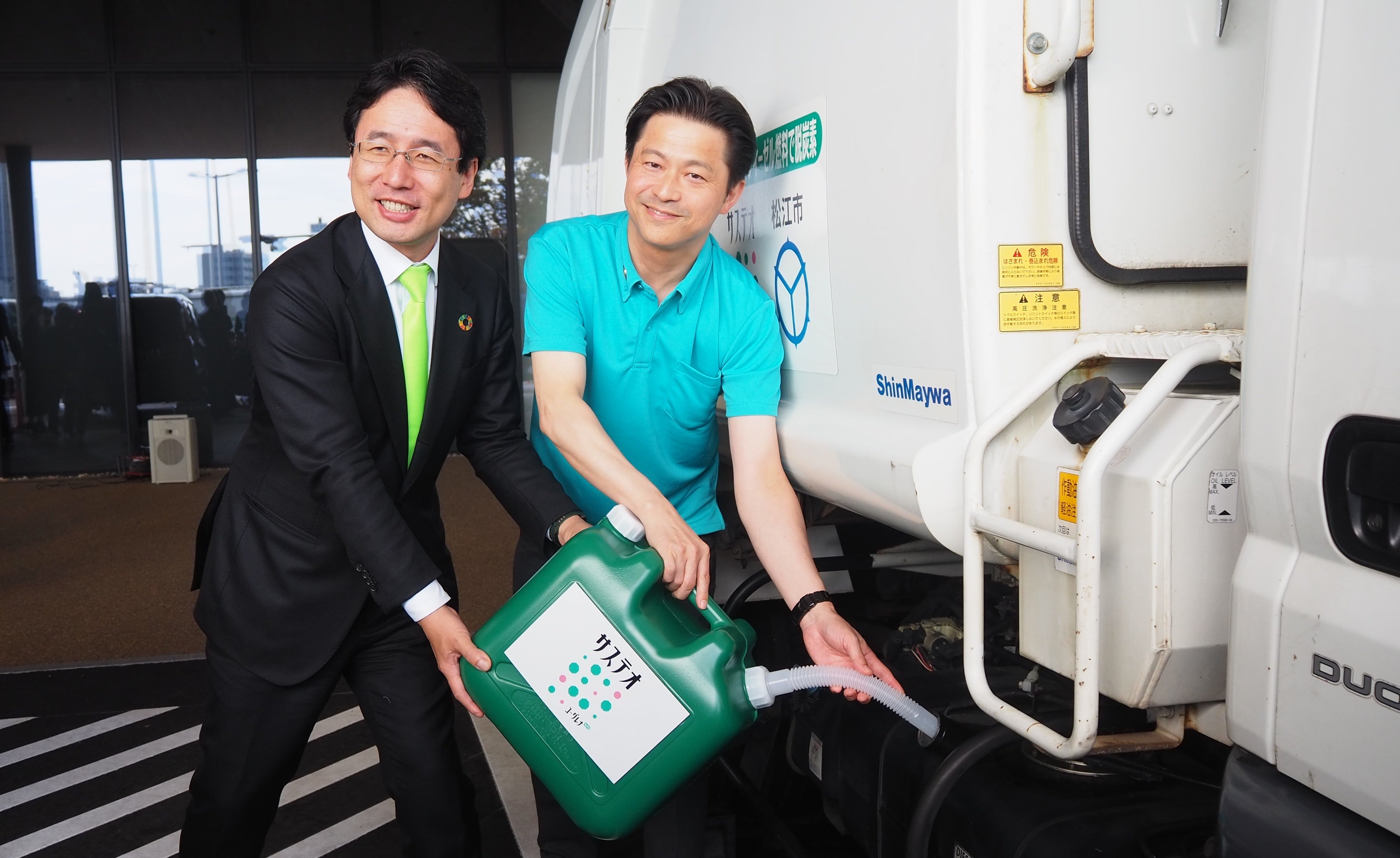 清掃収集車に「サステオ」を給油する様子 左から、ユーグレナ社社長 出雲、松江市 上定市長