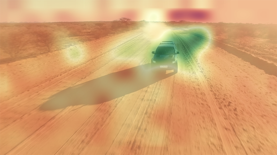 動画広告評価AI機能（β版）イメージ図：動画内にロゴなどを配置する場合において、広告効果が相対的に高い配置位置を赤色に、相対的に低い配置位置を緑色でビジュアライズ（本図の場合は、自動車の周りに配置するのは効果的ではないということが示されている）