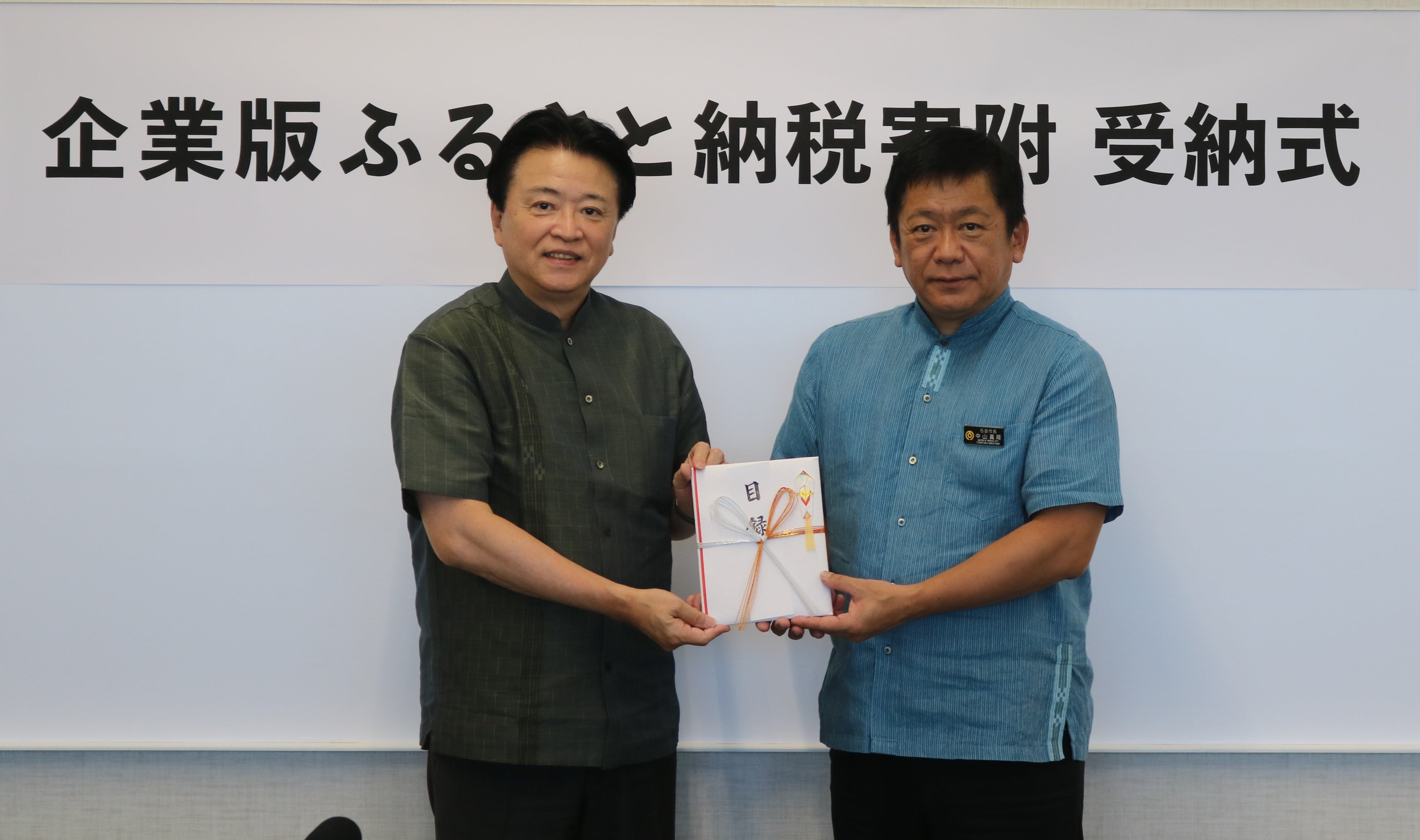 2023年10月11日 石垣市役所にて実施した企業版ふるさと納税寄付贈呈式。（左から）プレミアグループ株式会社 代表取締役社長 柴田洋一、石垣市長 中山義隆