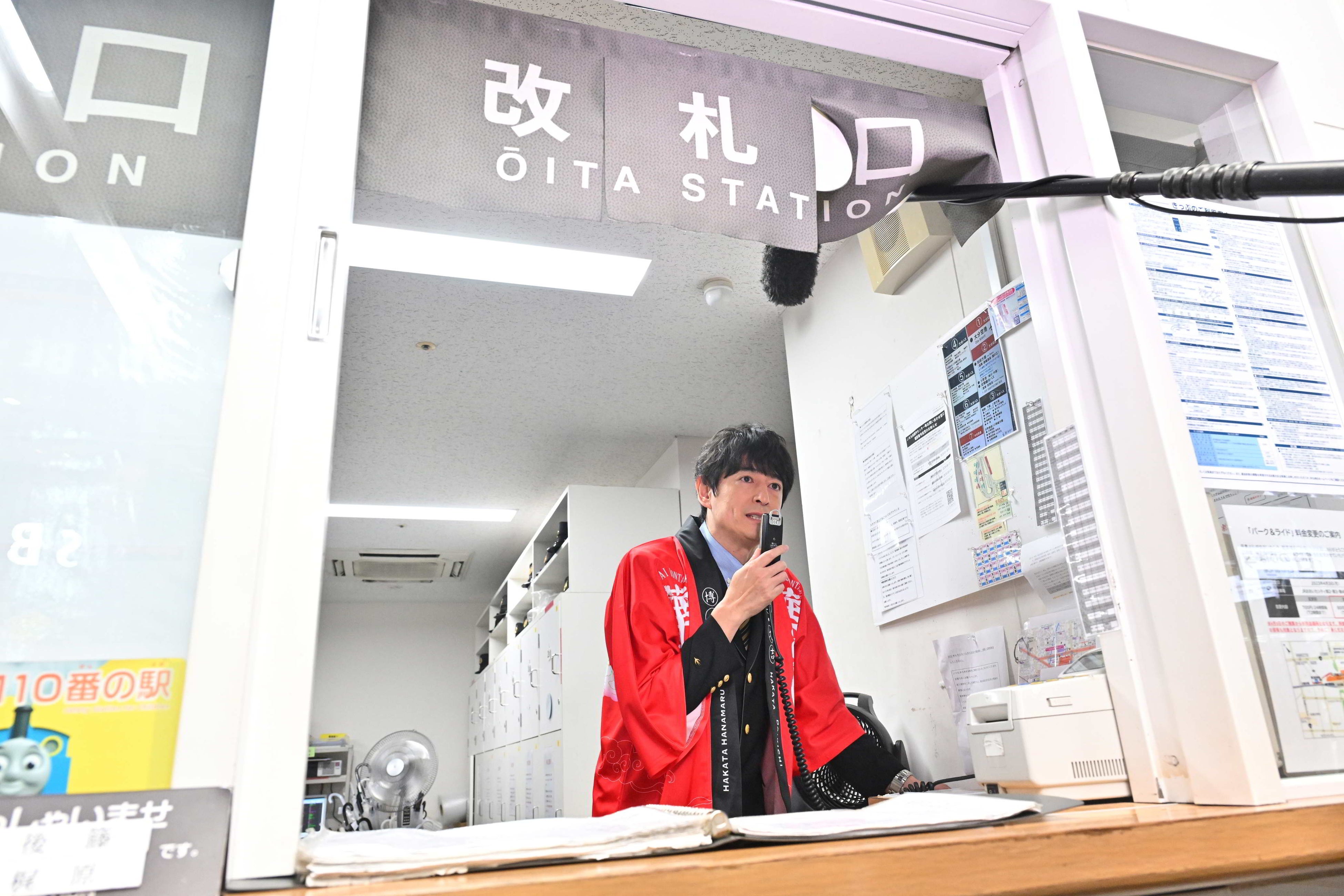 【改札口で放送を行う大吉さん】