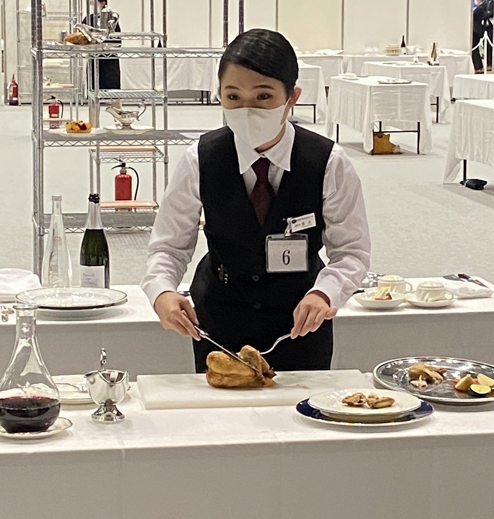 お客様と会話をしながらサービスする蓬田さん／若鶏のロースト デクパージュ