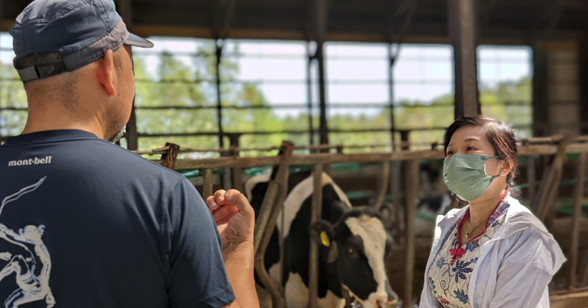 酪農家を現地視察するウォン氏（右）