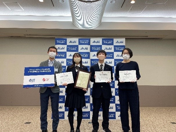 【最優秀賞を受賞した法政大学第二高等学校の研究メンバーとアサヒ飲料(株)・（株）リバネスのアドバイザー】
