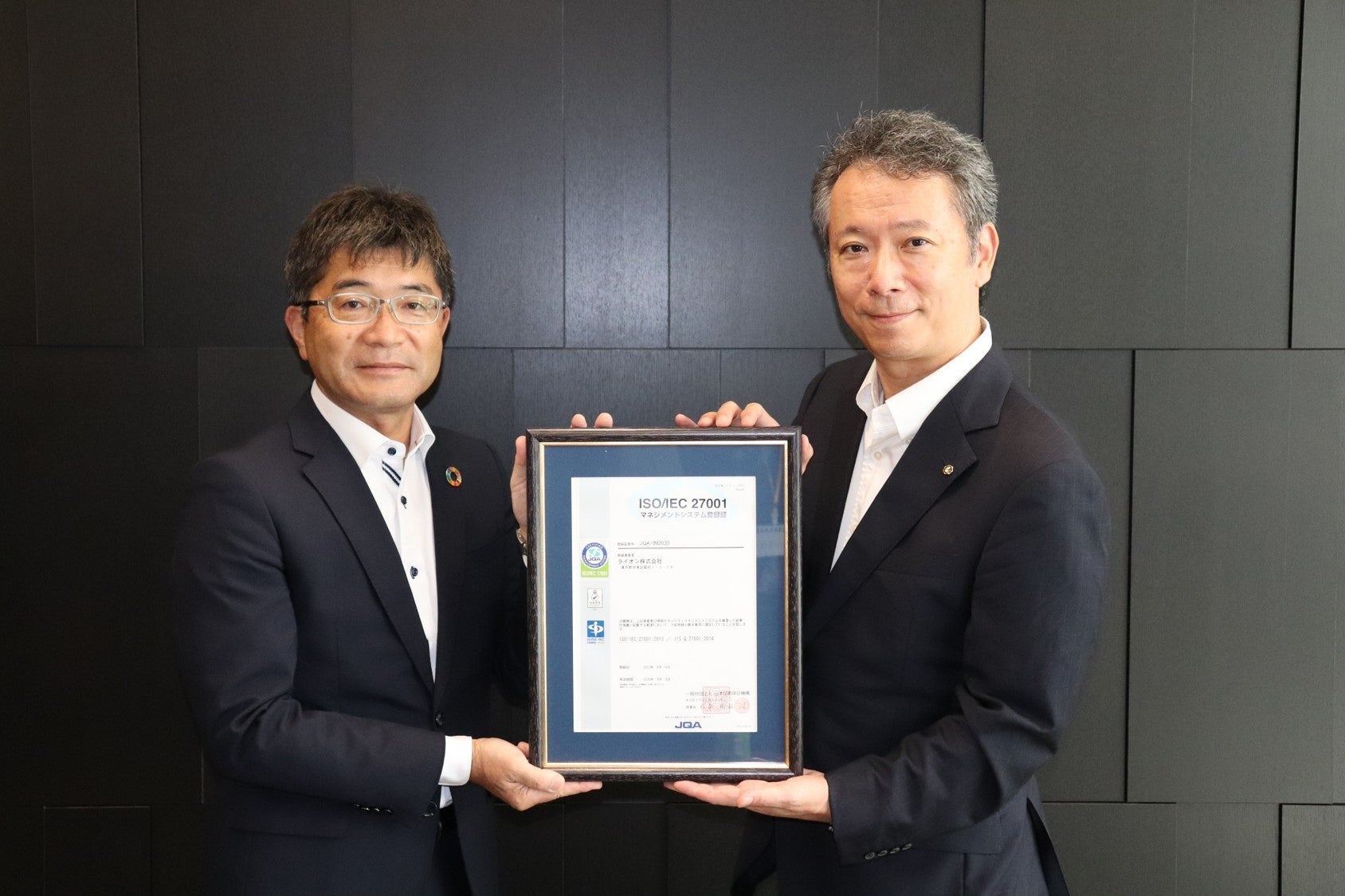 登録証の授与  （左）一般財団法人日本品質保証機構 マネジメントシステム部門 企画センター　松久 真人 所長  （右）ライオン株式会社 ビジネス開発センター　川西 敬之 本部長