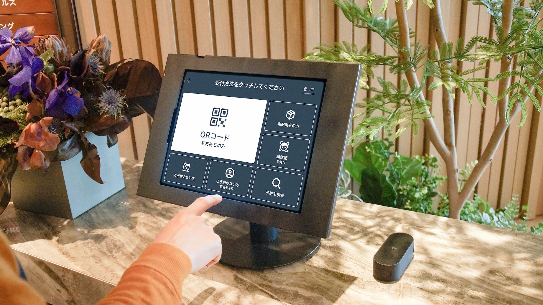 ゲストが受付端末を操作する様子（エントランス）