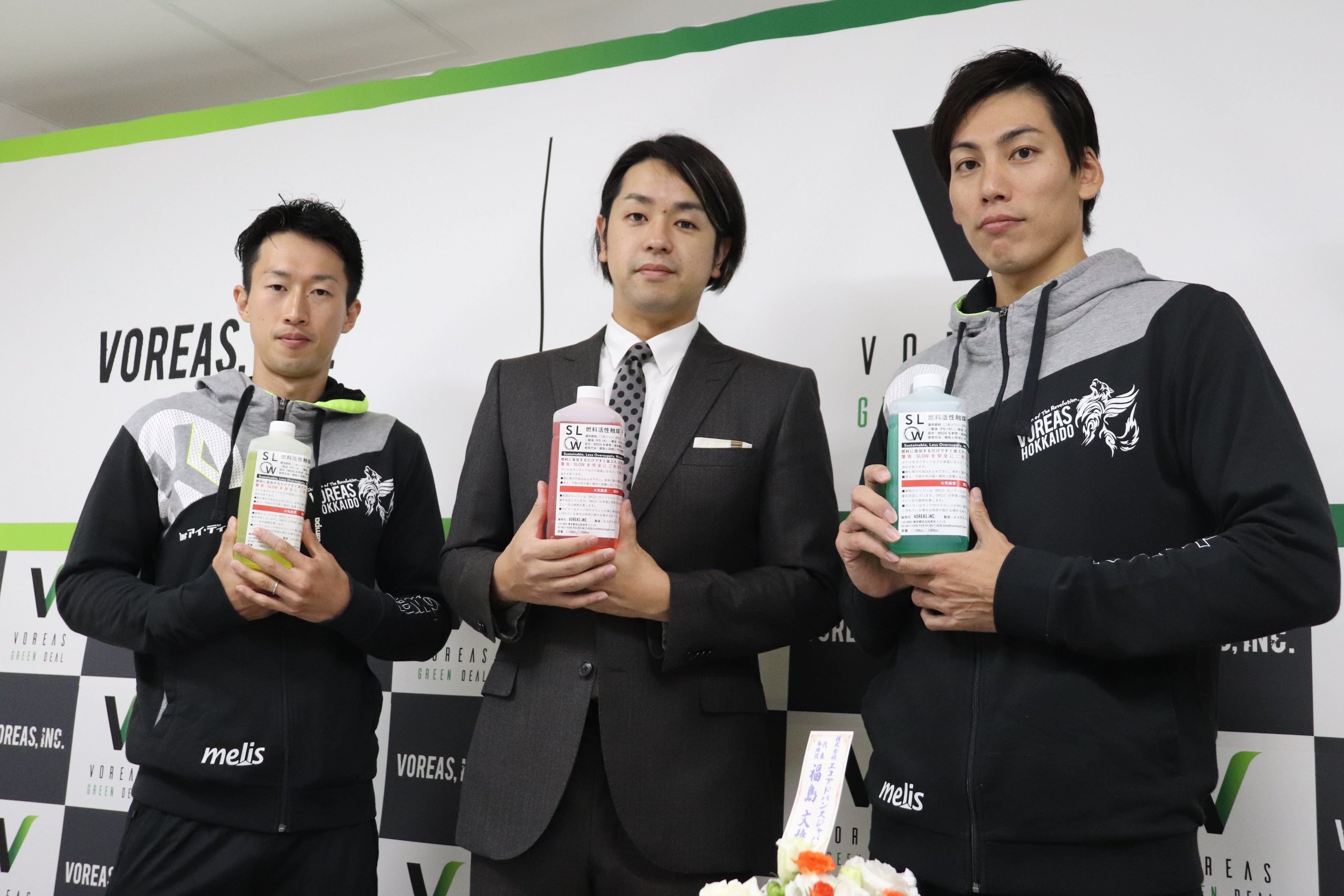 SLOWを手にとる、ヴォレアス北海道所属の元日本代表の越川優(右)・渡辺俊介(左)らと池田社長(中央)(2021年9月)