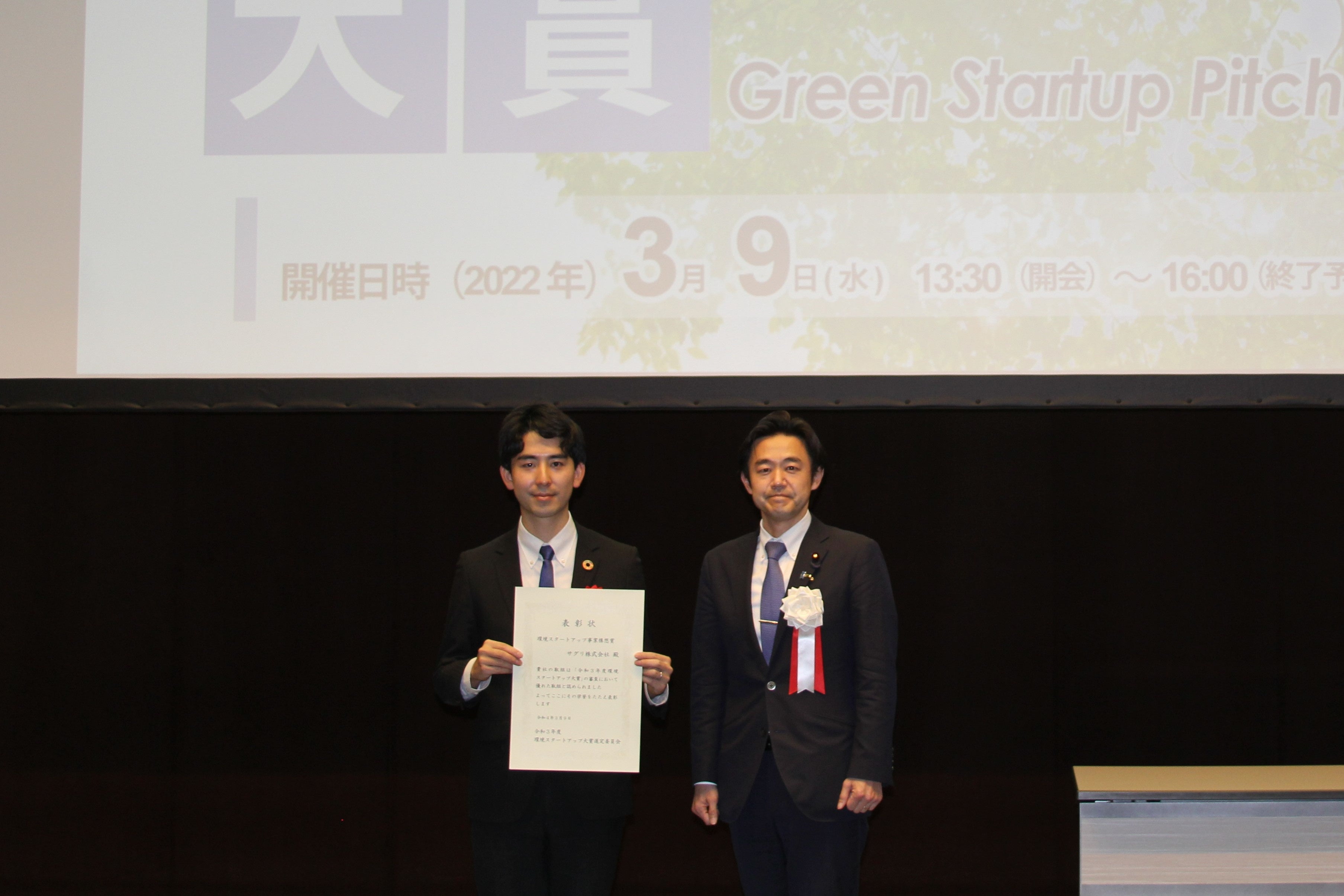 環境省穂坂環境大臣政務官及びサグリ株式会社代表取締役坪井俊輔の賞状授与式での記念撮影