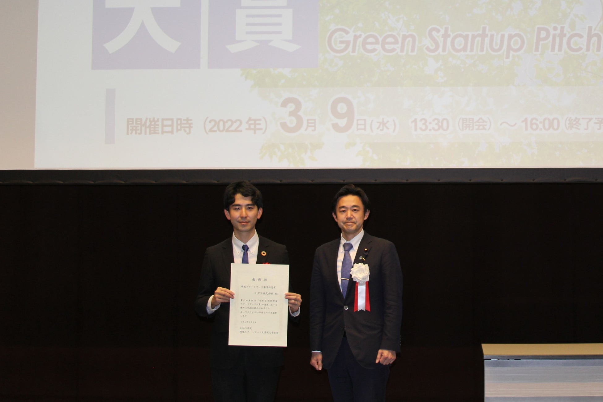 環境省穂坂環境大臣政務官及びサグリ株式会社代表取締役坪井俊輔の賞状授与式での記念撮影