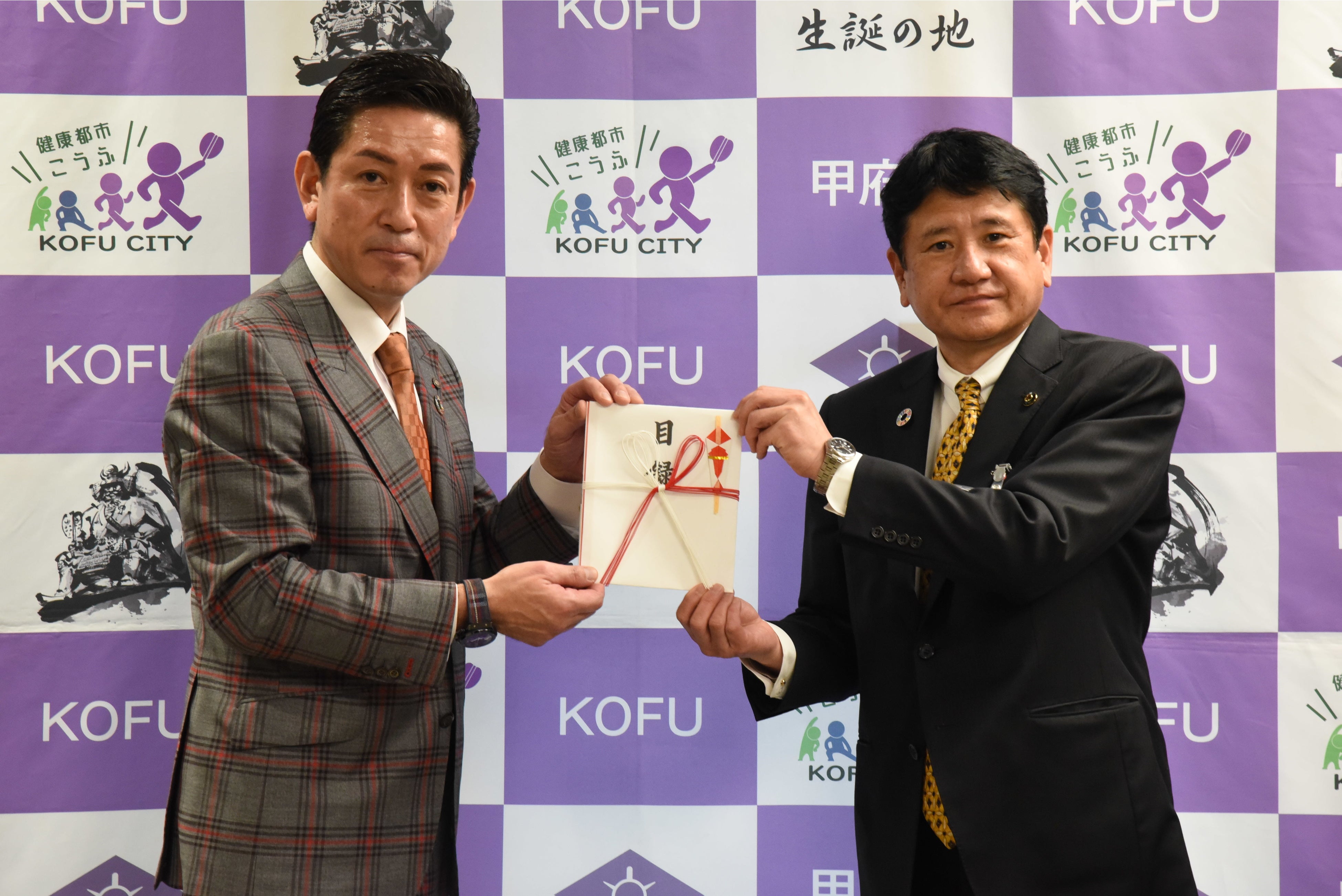 山梨県甲府市長樋口雄一氏へ寄付を行う佐々木の様子（受納式にて）