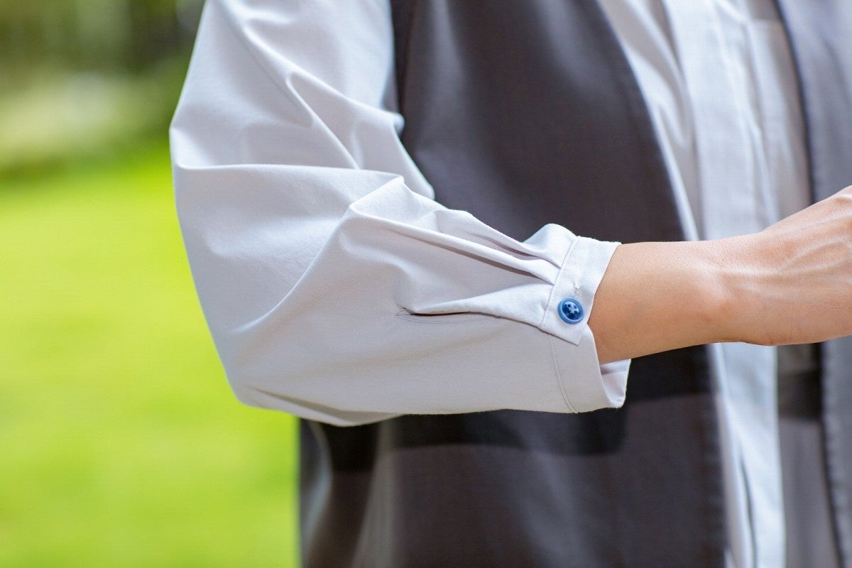 少し青みがかったアースカラーの生地や袖口の青いボタンは、いとまちを象徴する水をイメージ