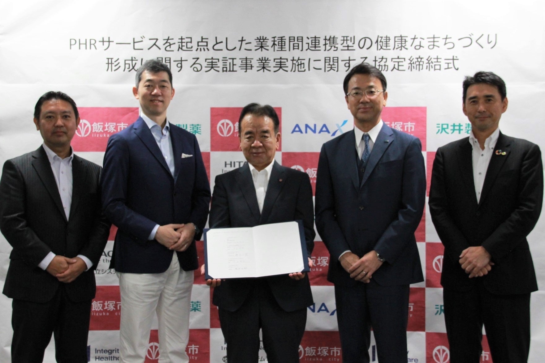 左からインテグリティ・ヘルスケア取締役・戸上 浩昭、ANA X代表取締役社長・轟木 一博、飯塚市副市長・久世 賢治、 沢井製薬理事・竹田 幸司、日立システムズ執行役員・長谷 正嗣