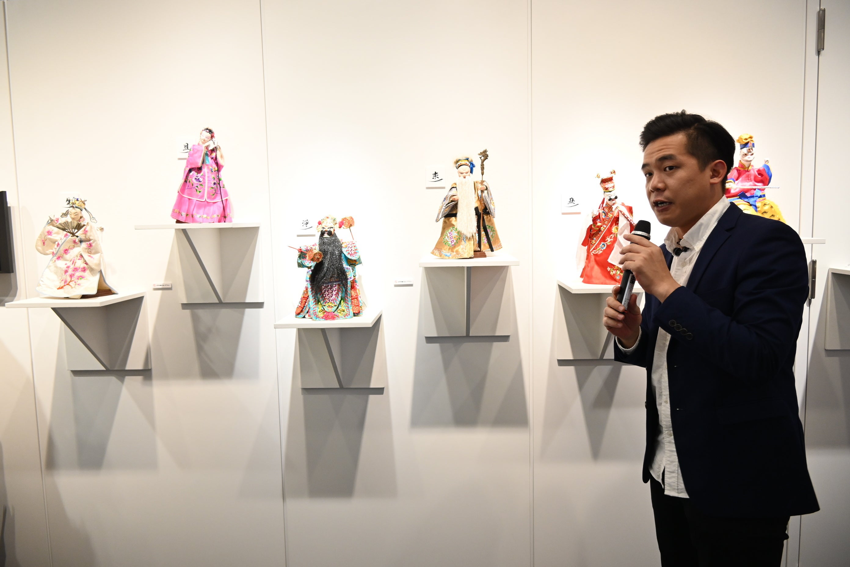 台湾布袋戯の人形について説明する台北木偶劇団の呉聲杰演師