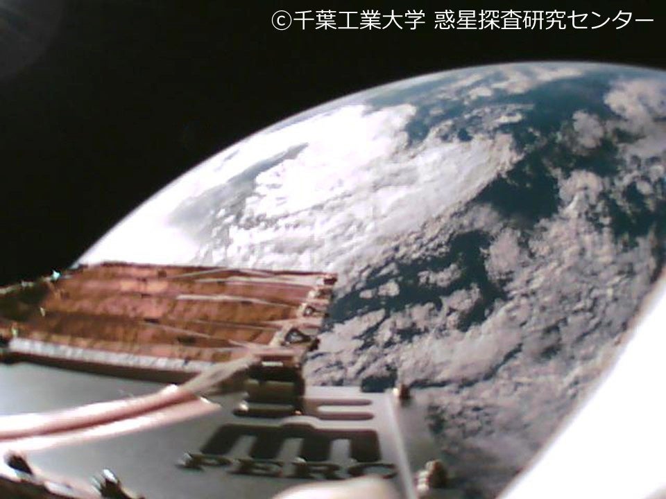 図2　展開した膜型ダストセンサーをオンボードカメラで撮影した自撮り画像。センサーが固定されたパドル面には千葉工業大学の校章とPERCのロゴが印字されている