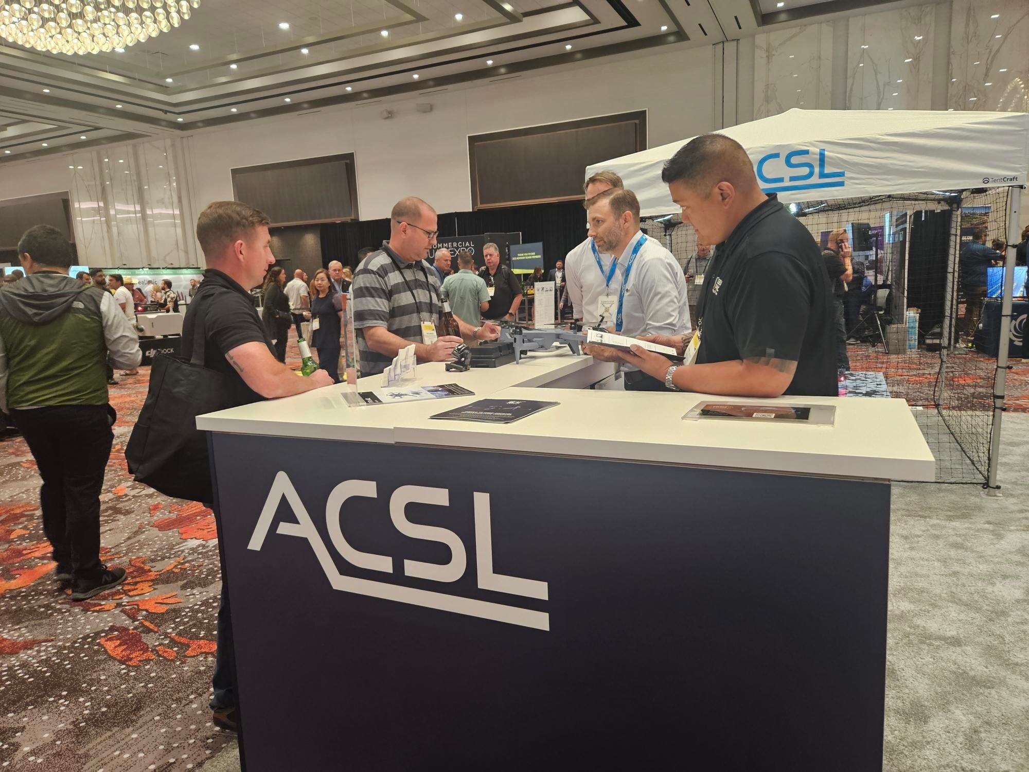 ＡＣＳＬブースの様子、ＡＣＳＬ社員やACSL, Inc.経営陣が日本発の小型空撮ドローンについて説明し関心が集まった