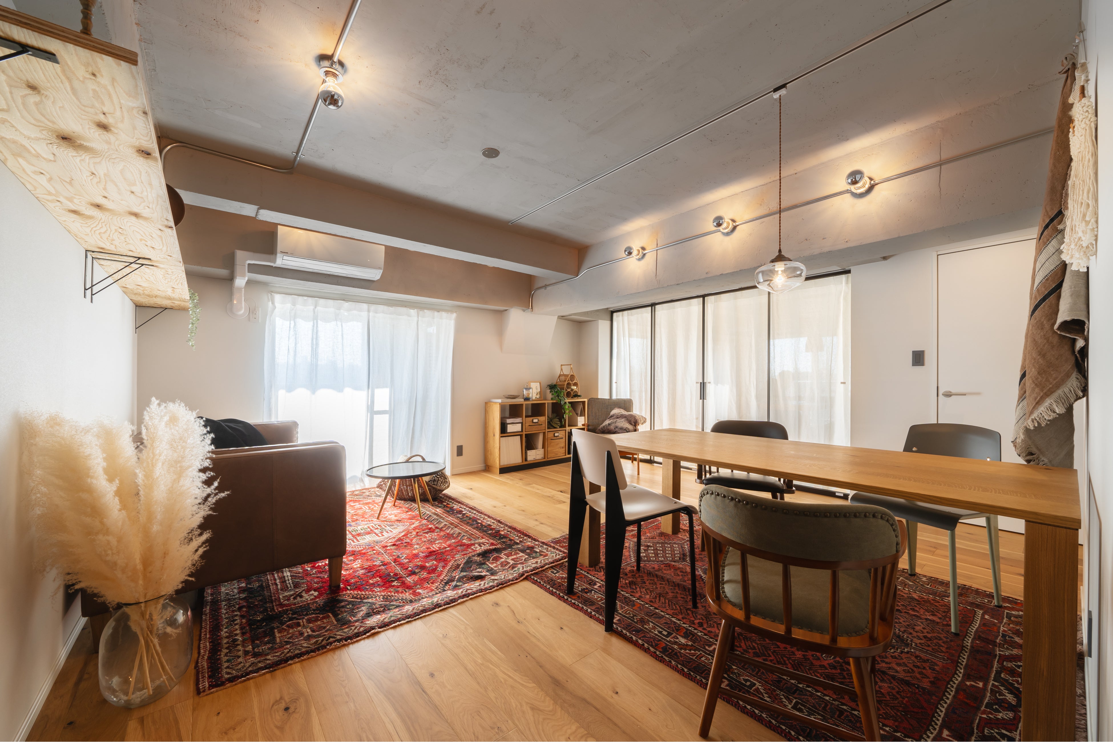 2種類の異なるヴィンテージのトライバルラグでリビング・ダイニングをゆるやかにゾーニング