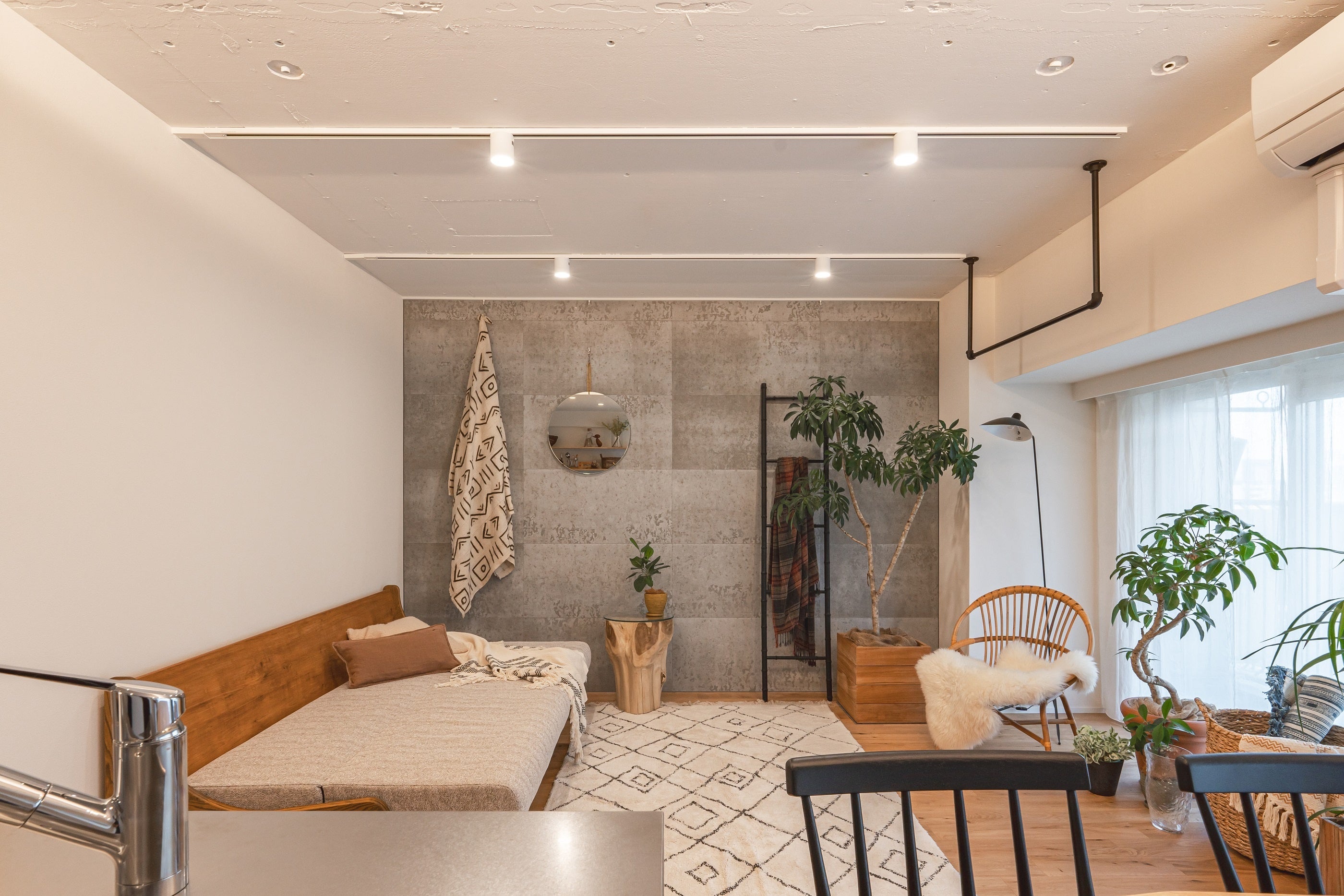 壁のグレーや家具の黒で引き締め、優しくなりすぎない工夫を