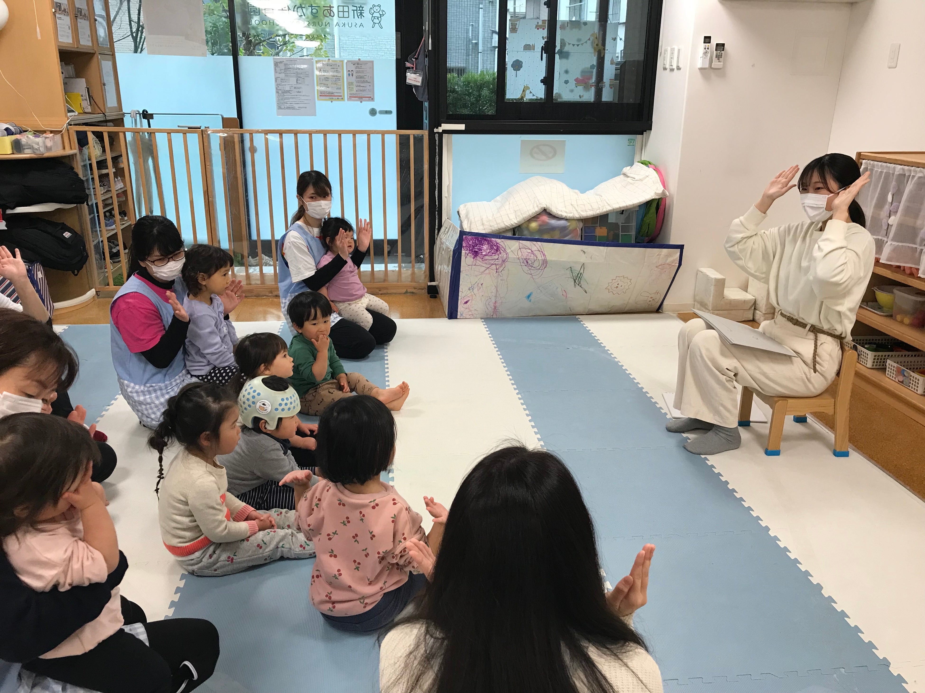 ＜手遊びで子どもたちの注目を集める保育学生の様子＞