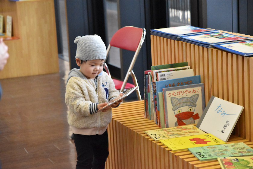 ＜絵本を手に取る子ども＞