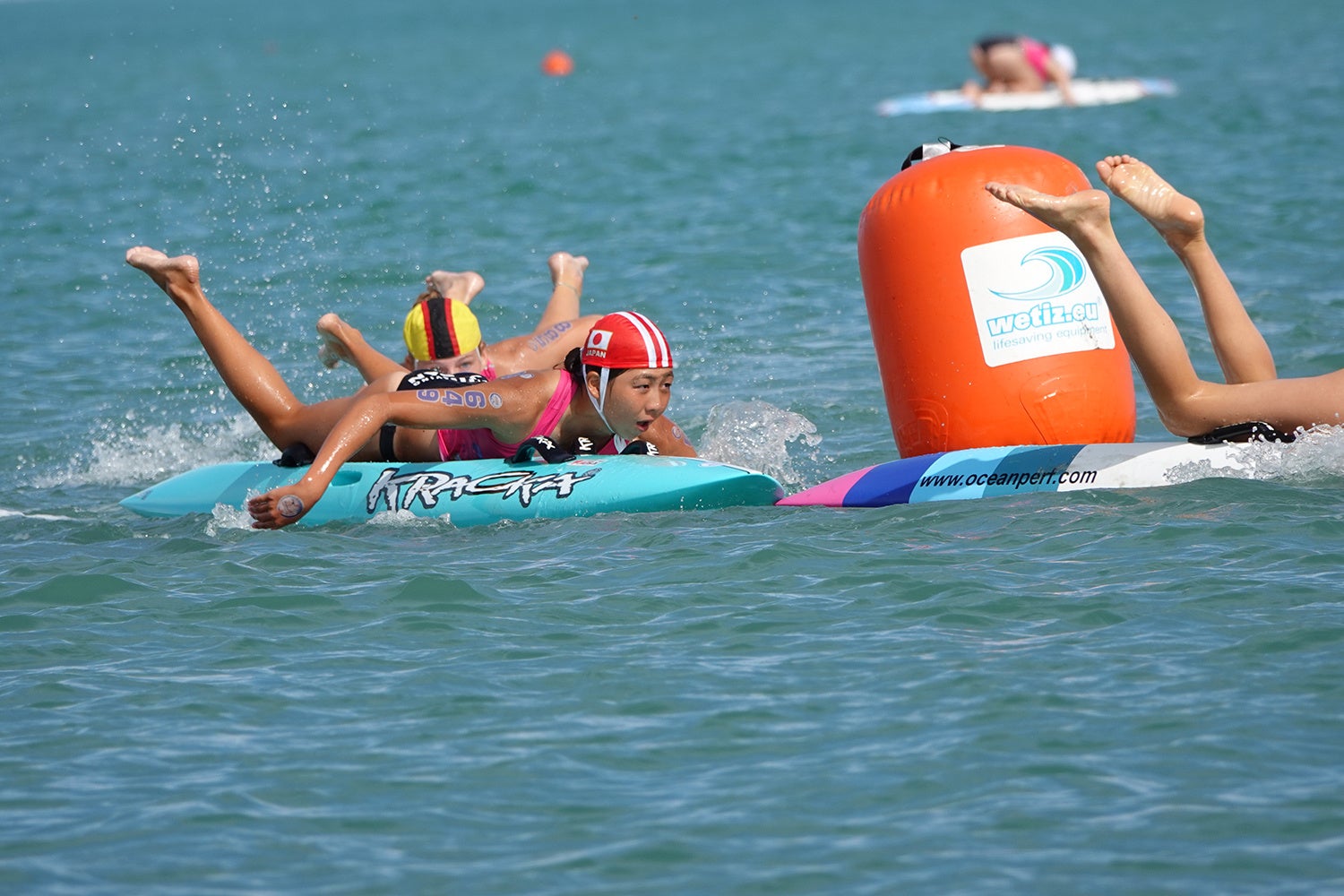 ユースミックスリレーでM字コースのブイをボードで折返す松岡鈴奈 