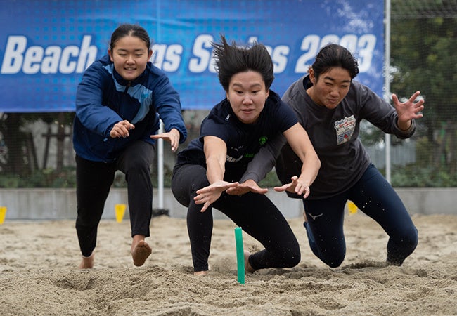 ビーチフラッグス女子準決勝の様子。3人で1本のフラッグを取り合うことも。