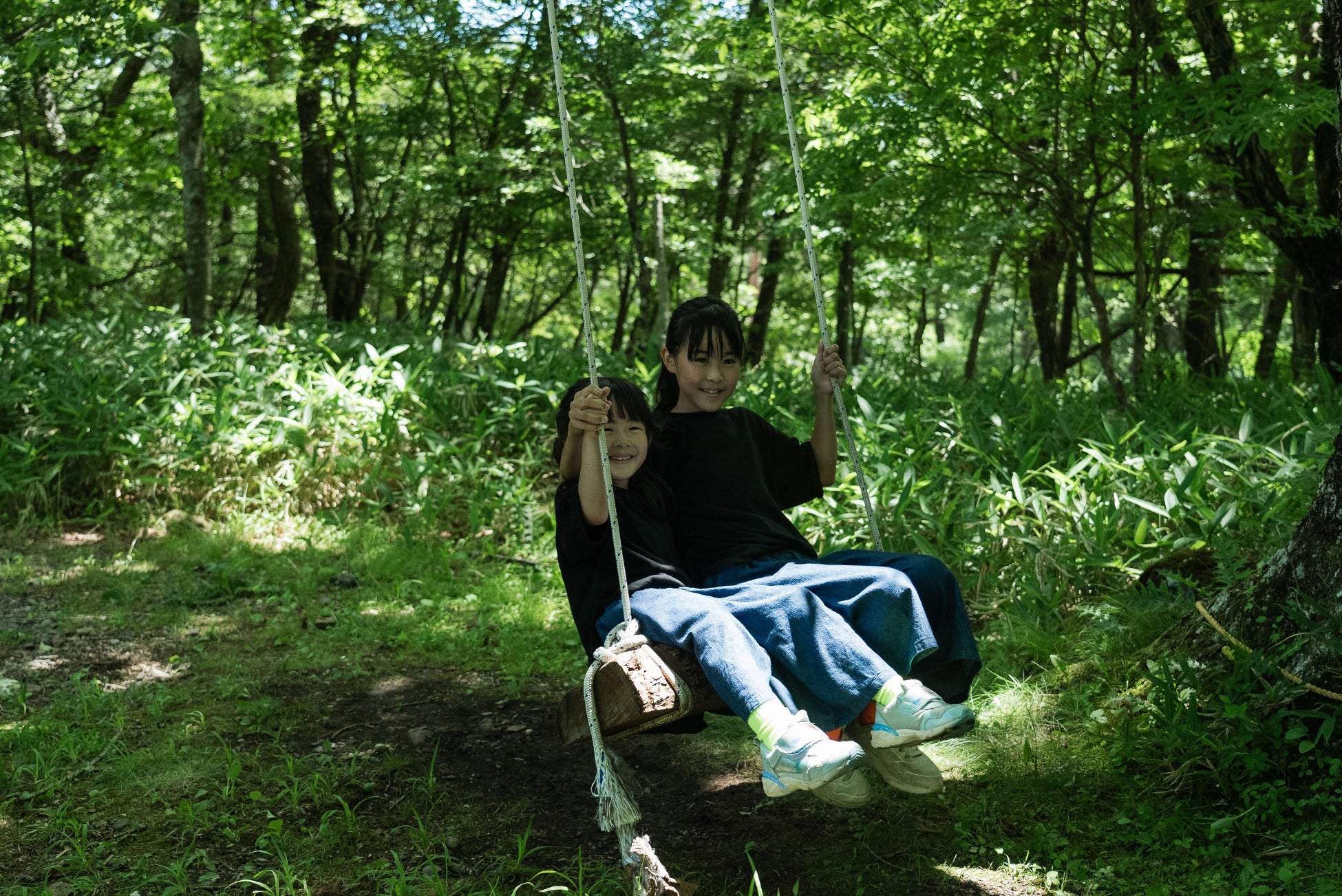 八ヶ岳の森の中でブランコに乗っている様子