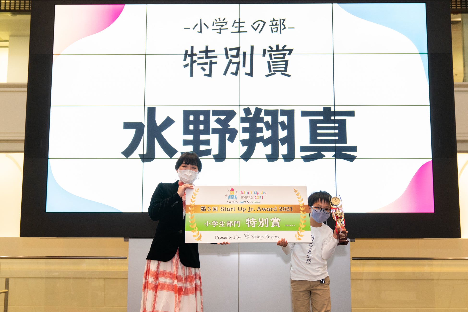 審査員の(株)マイナビ 学生の窓口マガジン編集長  高谷 理佳氏氏よりトロフィーとパネルを授与される 水野さん