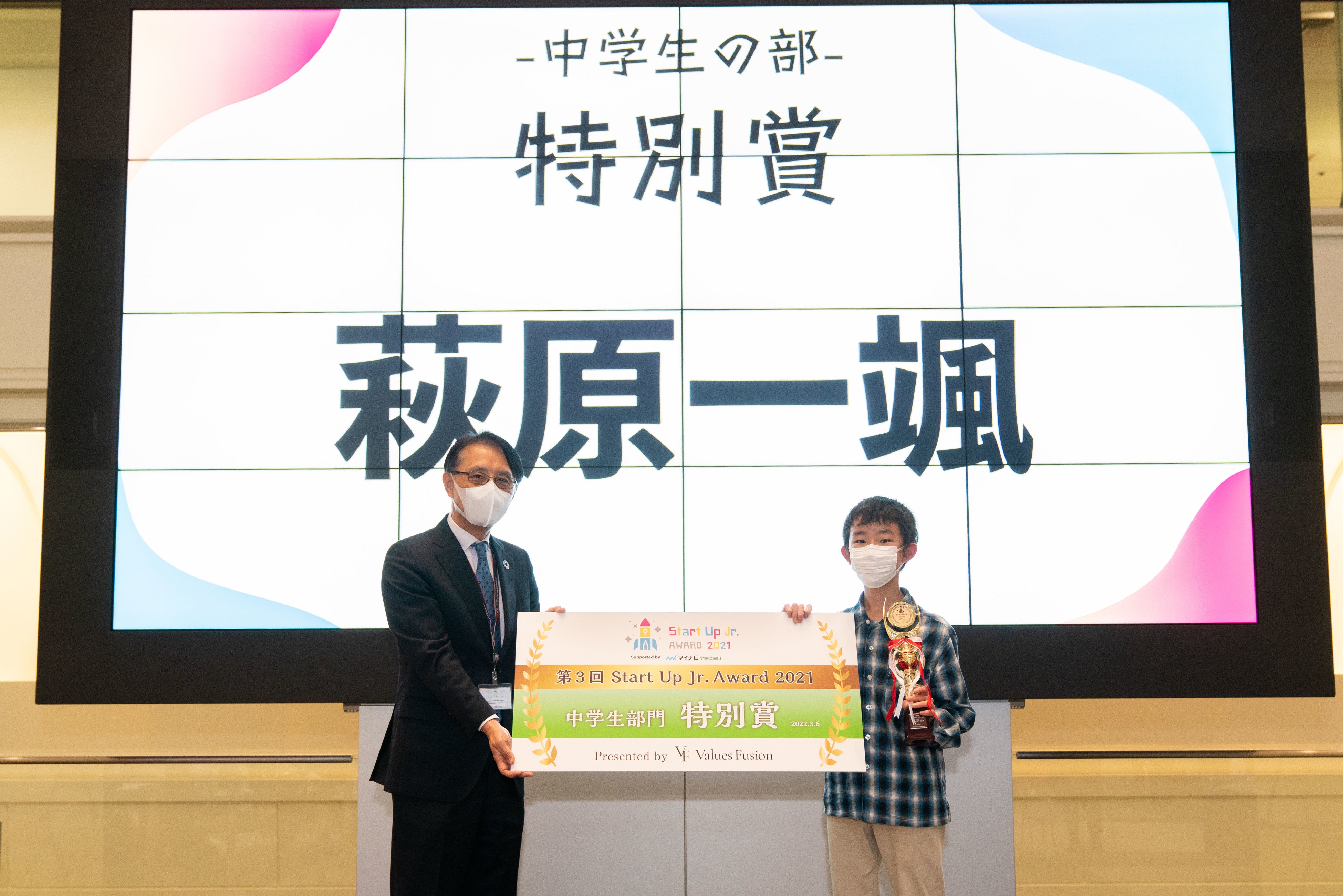 協賛の（株）東京証券取引所 長谷川高顕氏よりトロフィーとパネルを授与される萩原さん