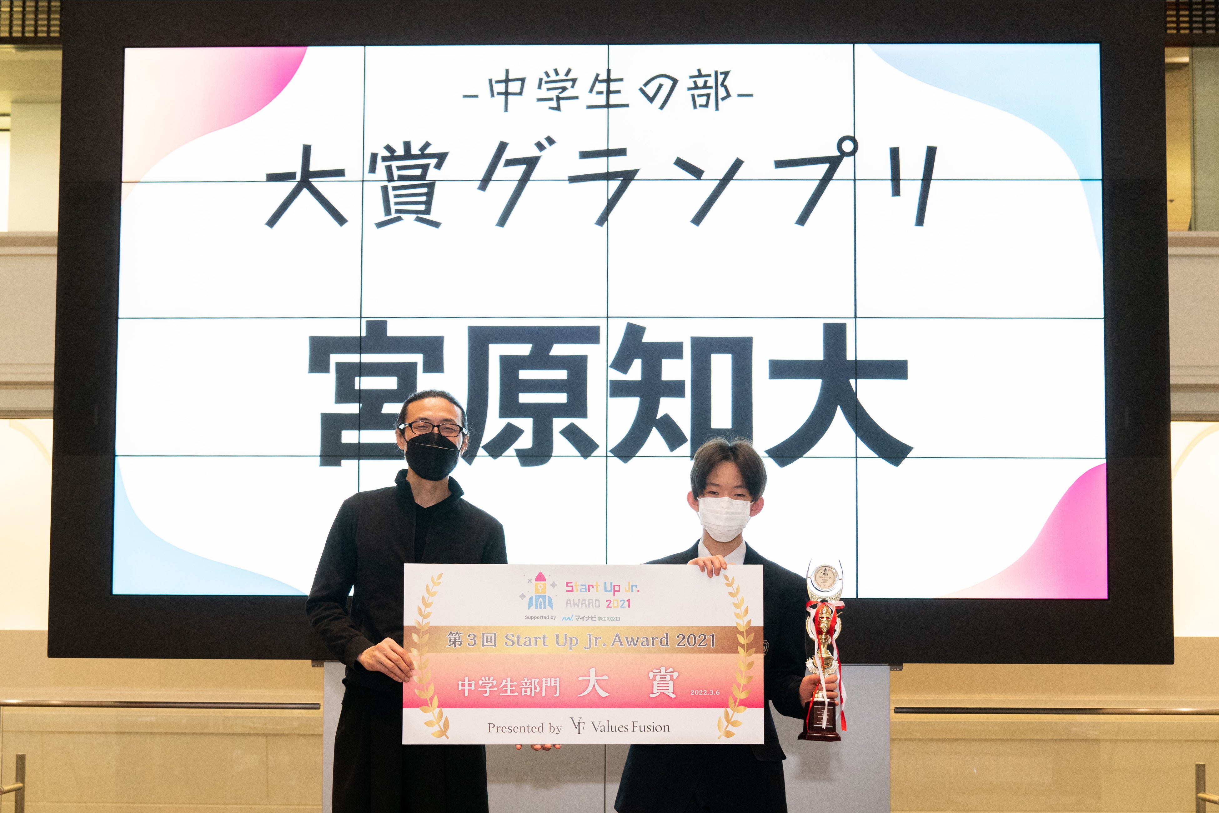 審査員長の（一社）プレゼンテーション協会代表理事 前田 鎌利氏よりトロフィーとパネルを 授与される宮原さん