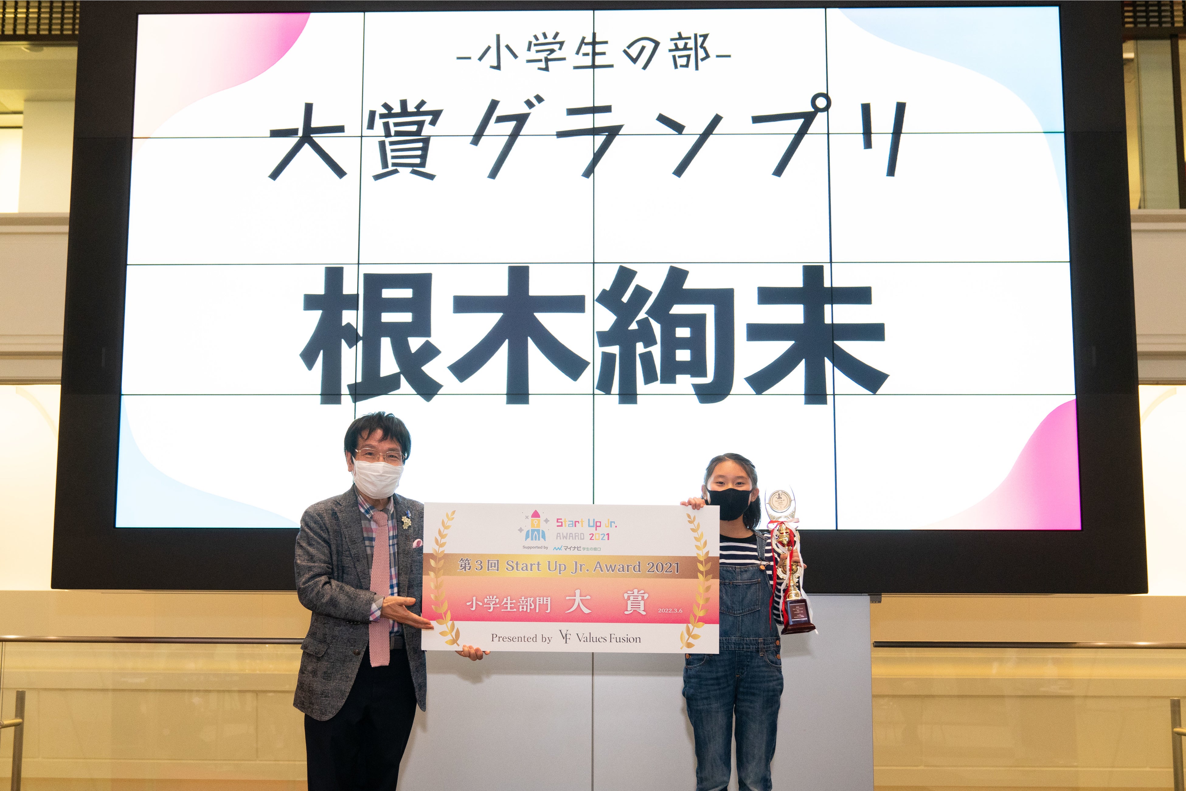 特別審査員の尾木ママよりトロフィーとパネルを授与される根木さん