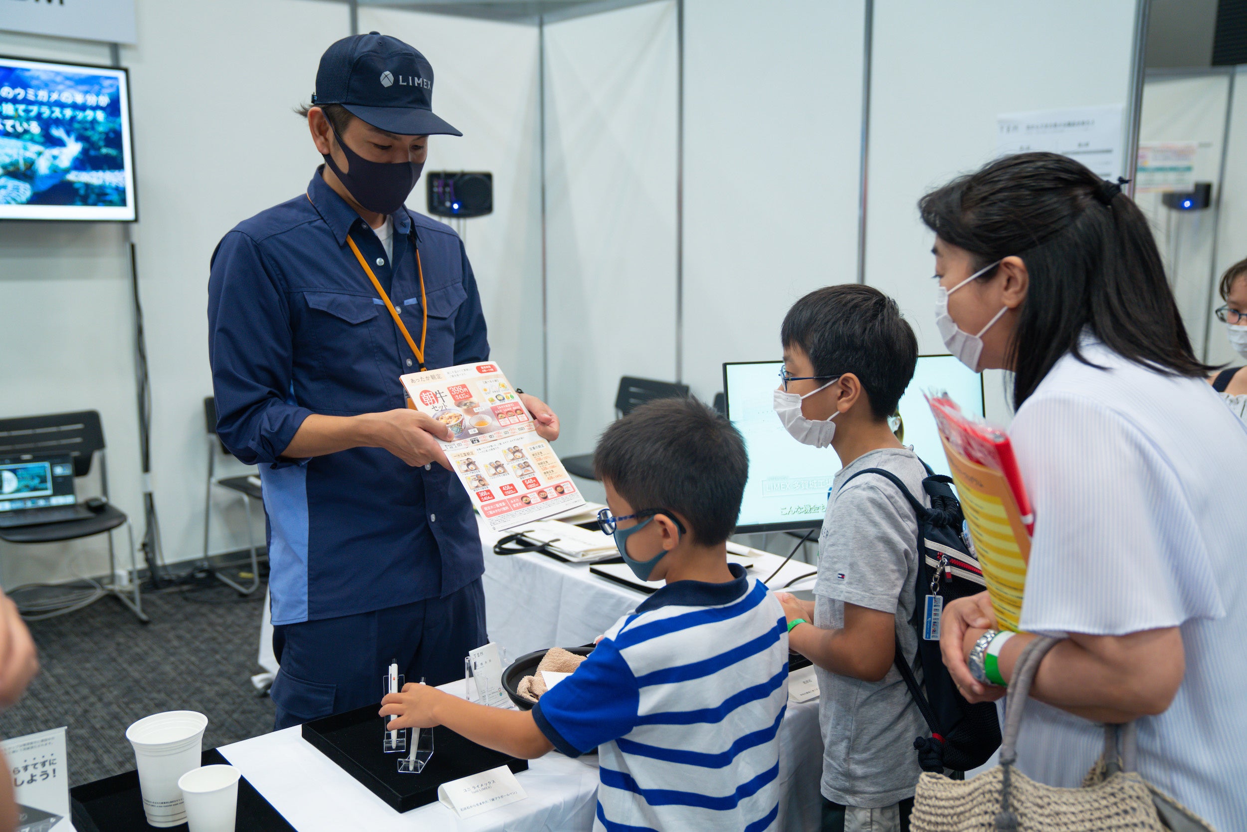 TBMのブースより。環境に配慮された新素材について学ぶ子どもたち。