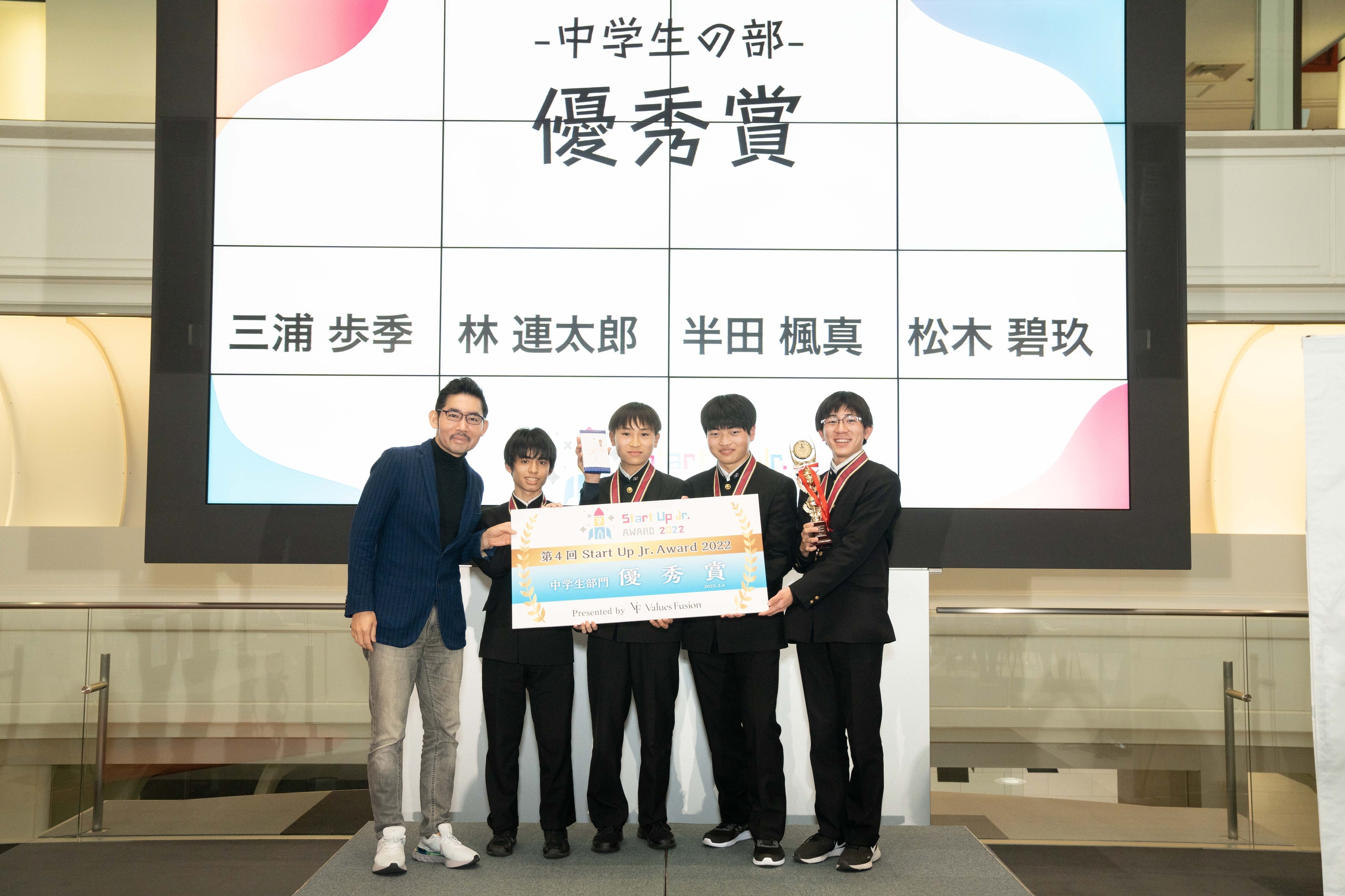 審査員のPIVOT（株）CEO 佐々木紀彦氏よりトロフィーとパネルを授与される三浦歩季さん、林連太郎さん、半田楓真さん、松木碧玖さん