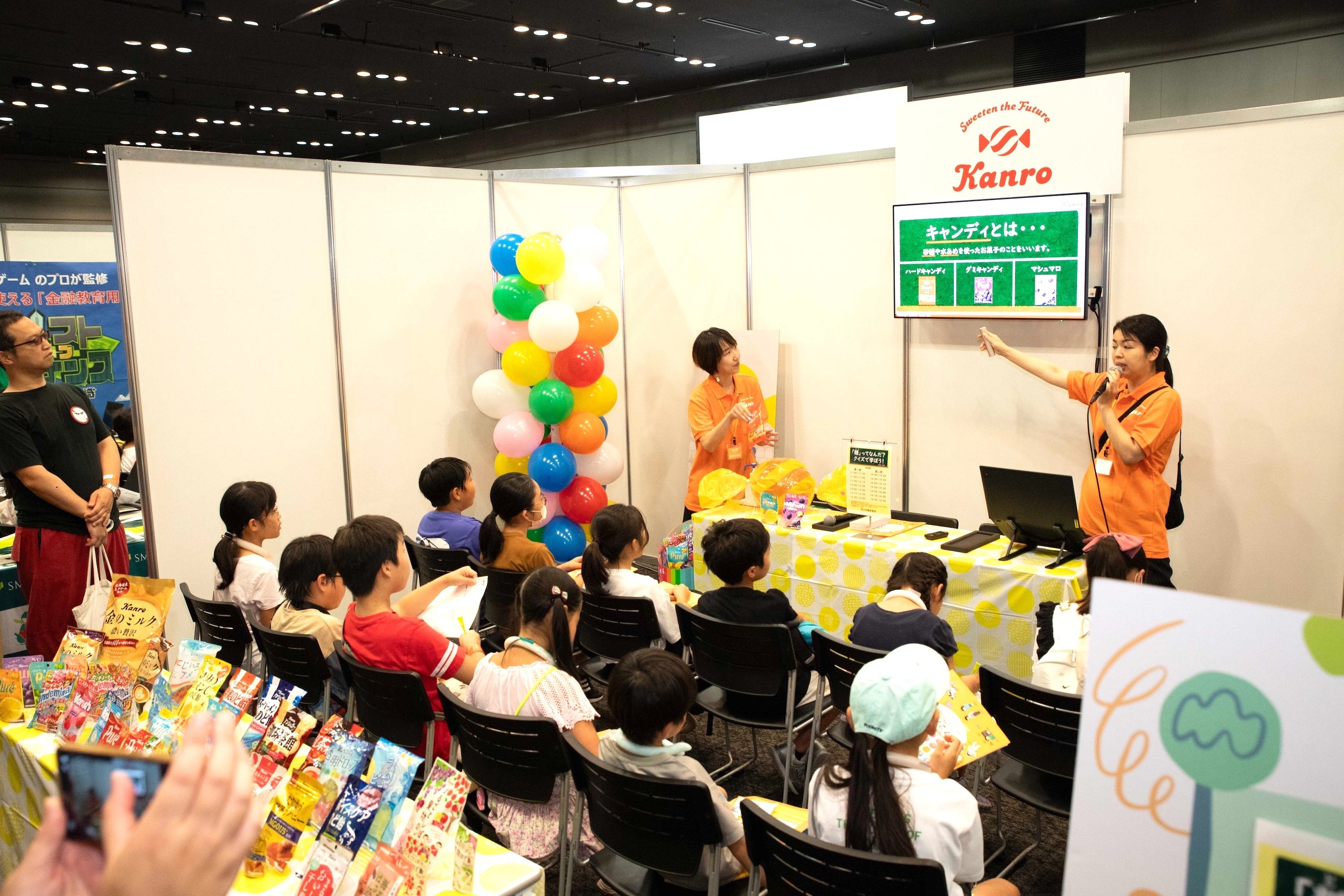 カンロのブースより。糖の機能や役割をクイズやアニメで楽しく学ぶ子どもたち