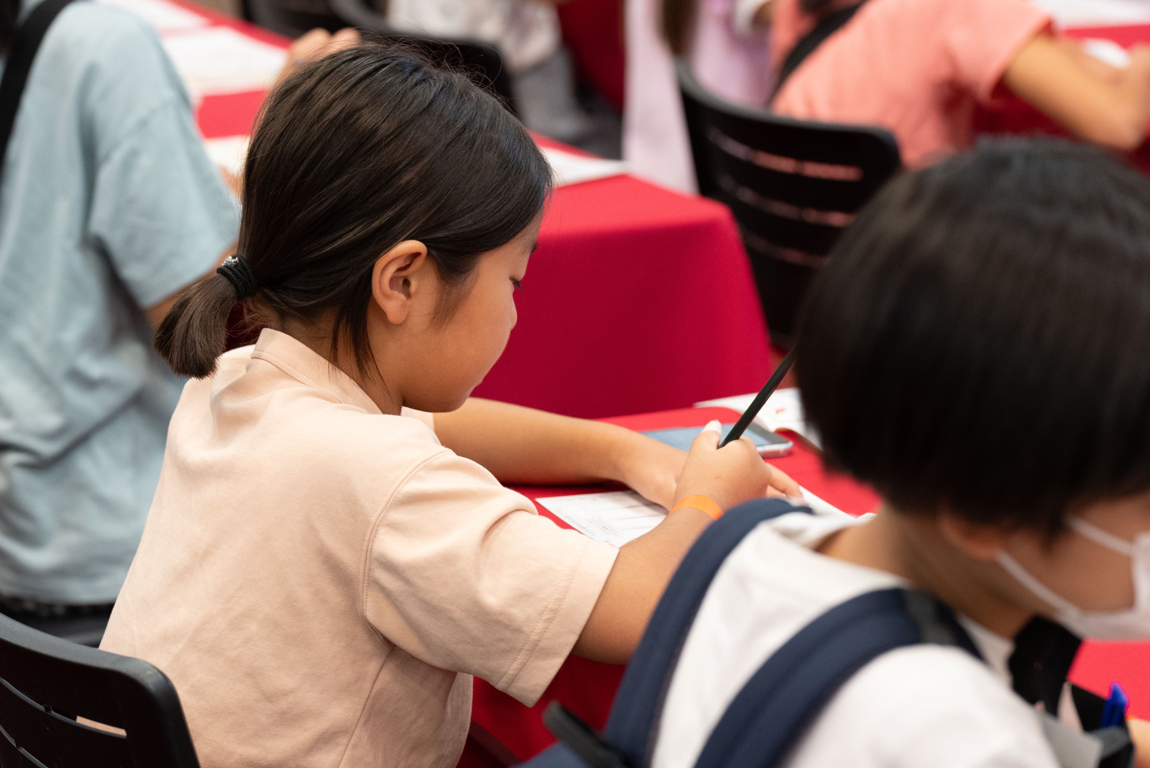 日本郵便のブースより。葉書に宛名を書く体験を通じて、手紙が届く仕組みを学ぶ子どもたち