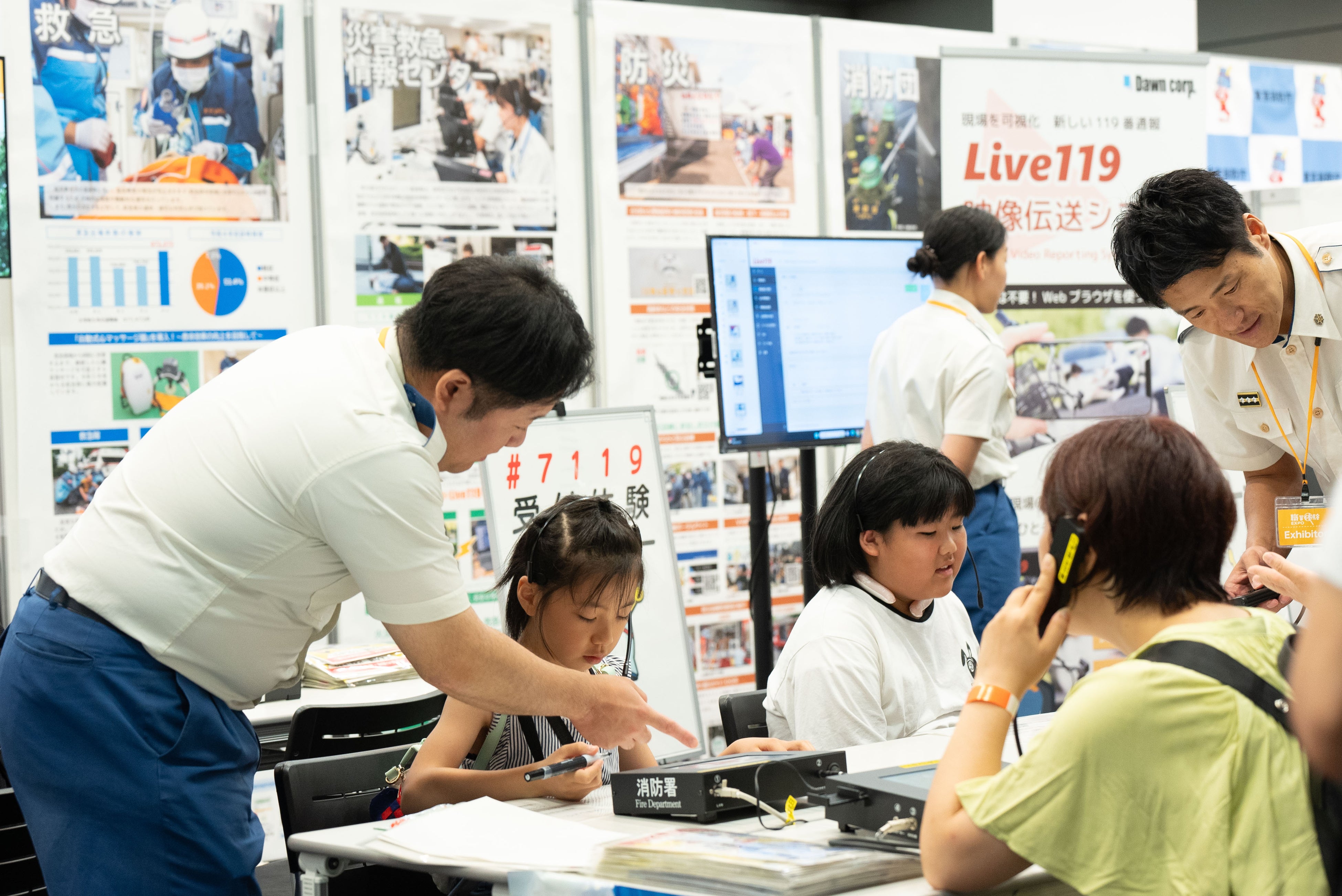 東京消防庁のブースより。消防庁の様々な仕事の紹介や119番通報について学ぶ子どもたち