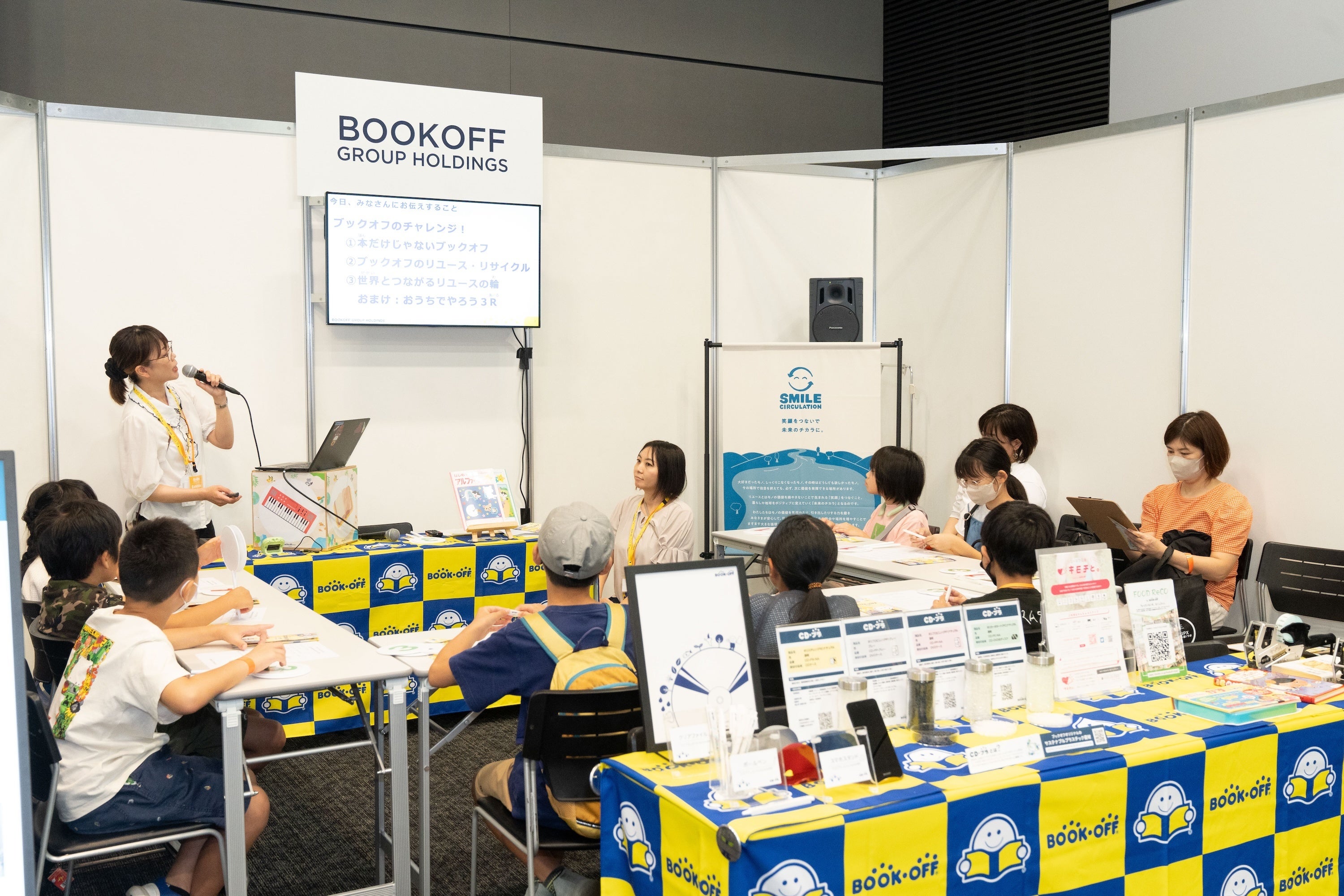 ブックオフグループホールディングスのブースより。ブックオフが行なっているリユース、リサイクルについて学ぶ子どもたち