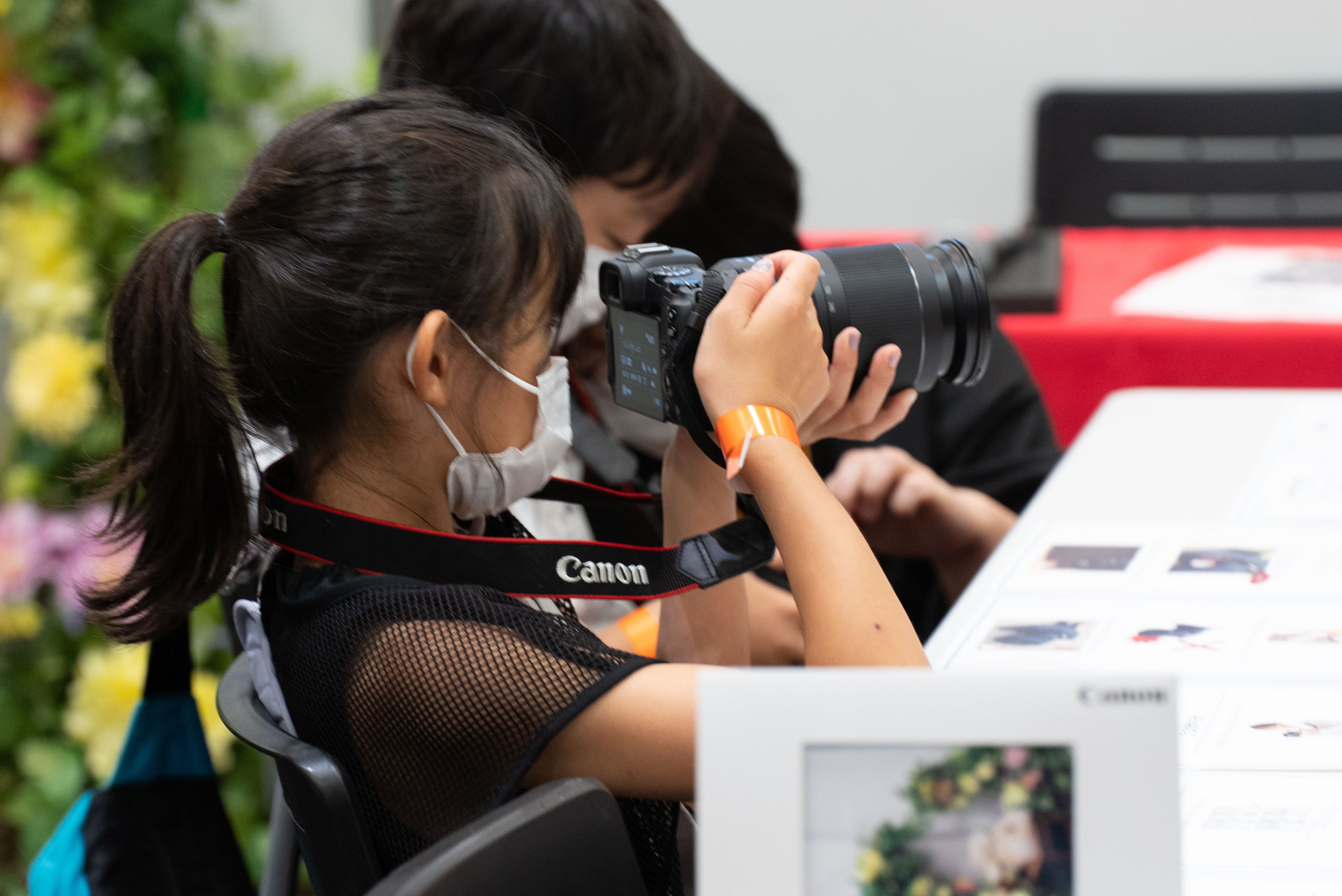 キヤノンマーケティングジャパンのブースより。実際にカメラを使って写真の撮り方を学ぶ子どもたち