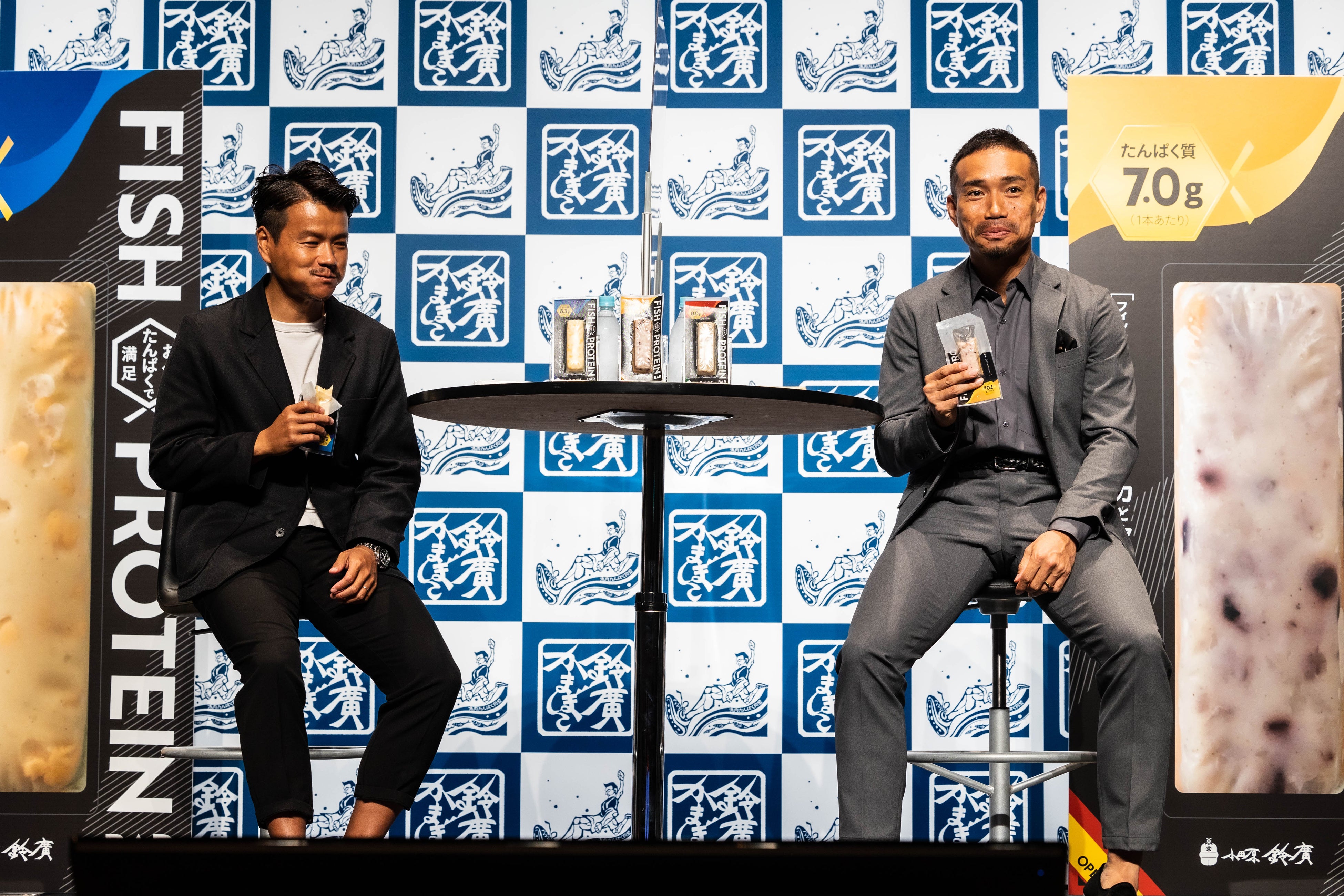 フィッシュプロテインバーを試食する加藤超也シェフ（左）と長友佑都選手（右）