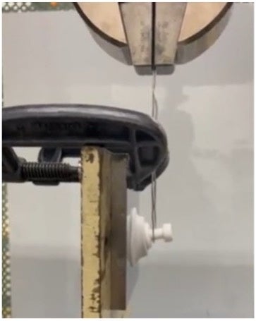 耐荷重実験時の写真。  上部から強い力で引っ張る様子