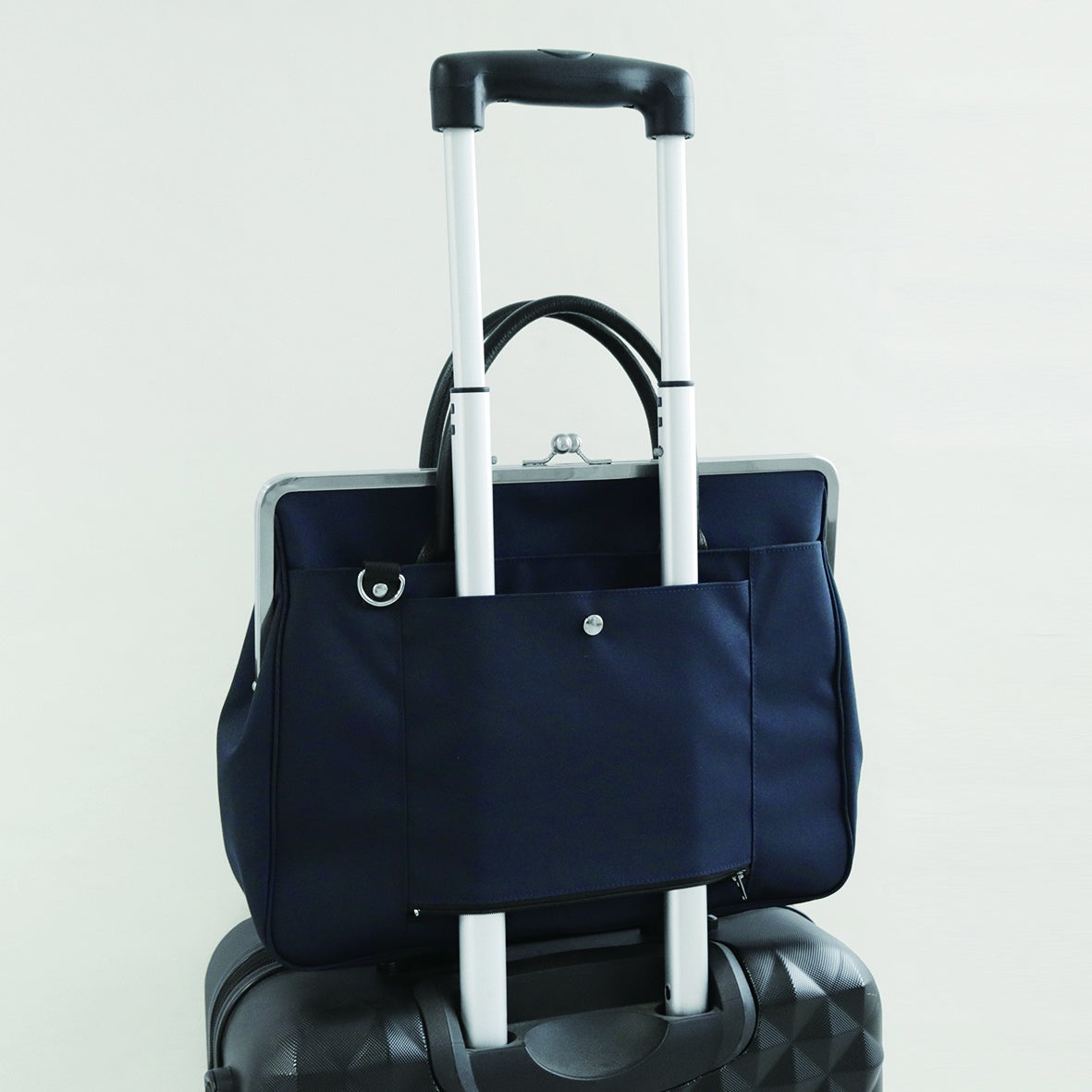 背面のファスナー付きポケットは、ファスナーを開けてキャリーバーに通せばスーツケースを持った移動も楽々！