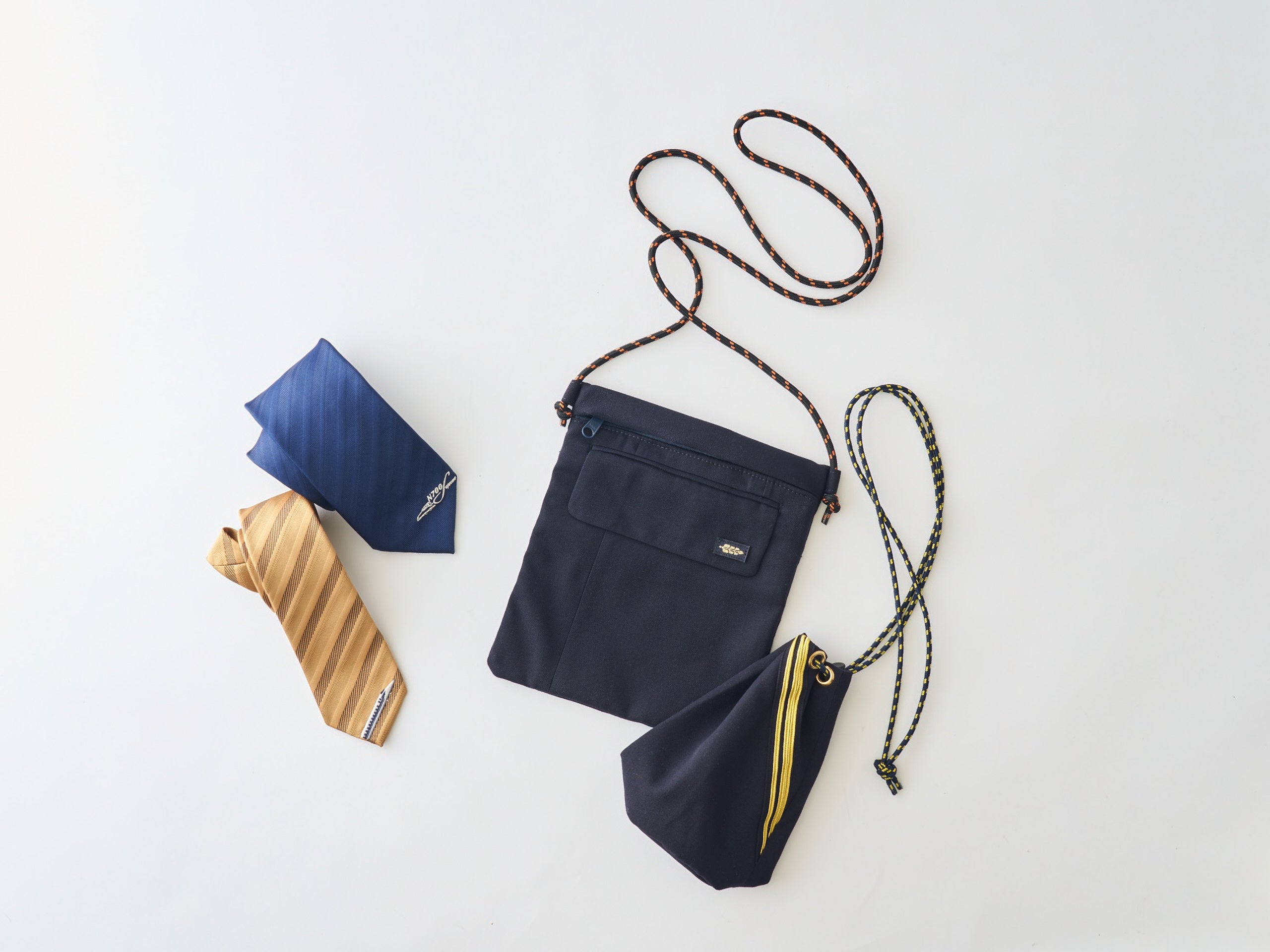 愛知県名古屋市 ＜ここ鉄（ジェイアール東海商事）＞ 左：ワンポイント刺しゅうネクタイ 各6,160円 右上：サコッシュ 6,270円&nbsp; 右下：巾着（ショルダー 4,400円