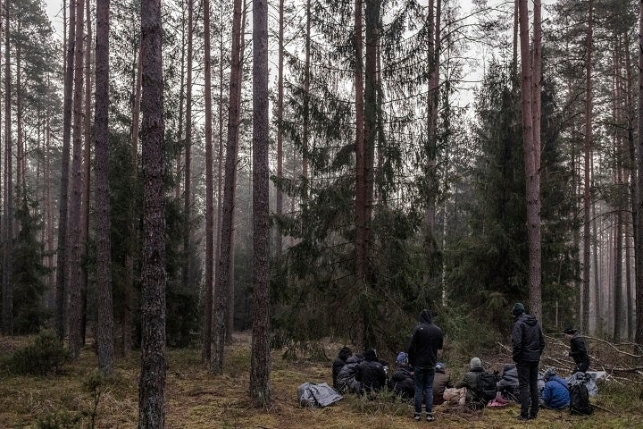 支援団体から食料や防寒着などを受け取り、移動を続けるイエメン人とパレスチナ人のグループ＝2021年11月1日