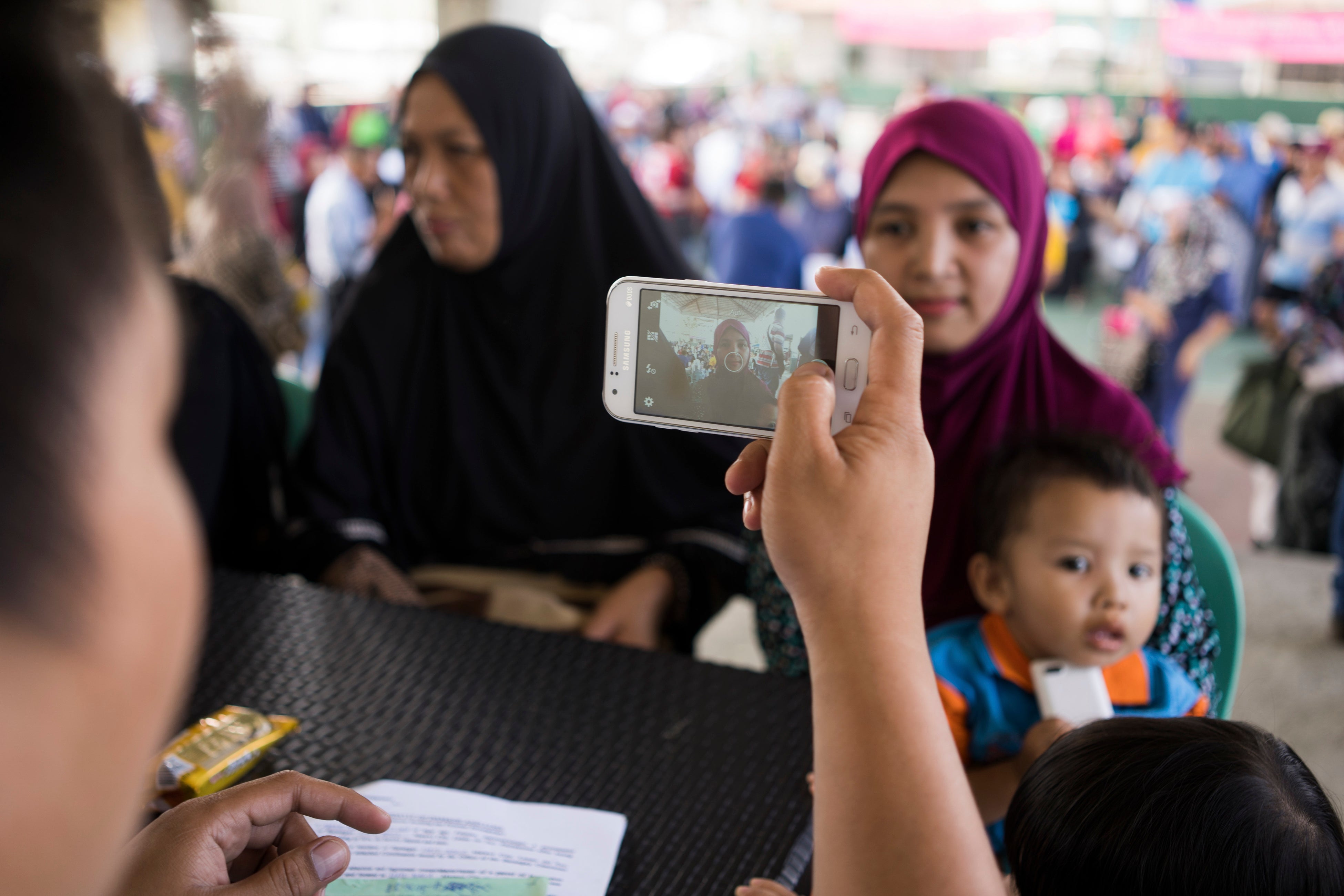 フィリピンのマラウィ市で生活支援をするため、スマホのアプリで避難者を登録するICRCスタッフ ©ICRC