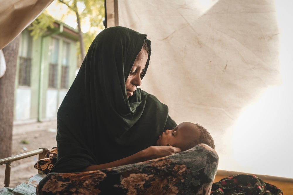 入院栄養治療センターで息子が寝ているのを見守る母親＝2022年6月1日　© Njiiri Karago／MSF