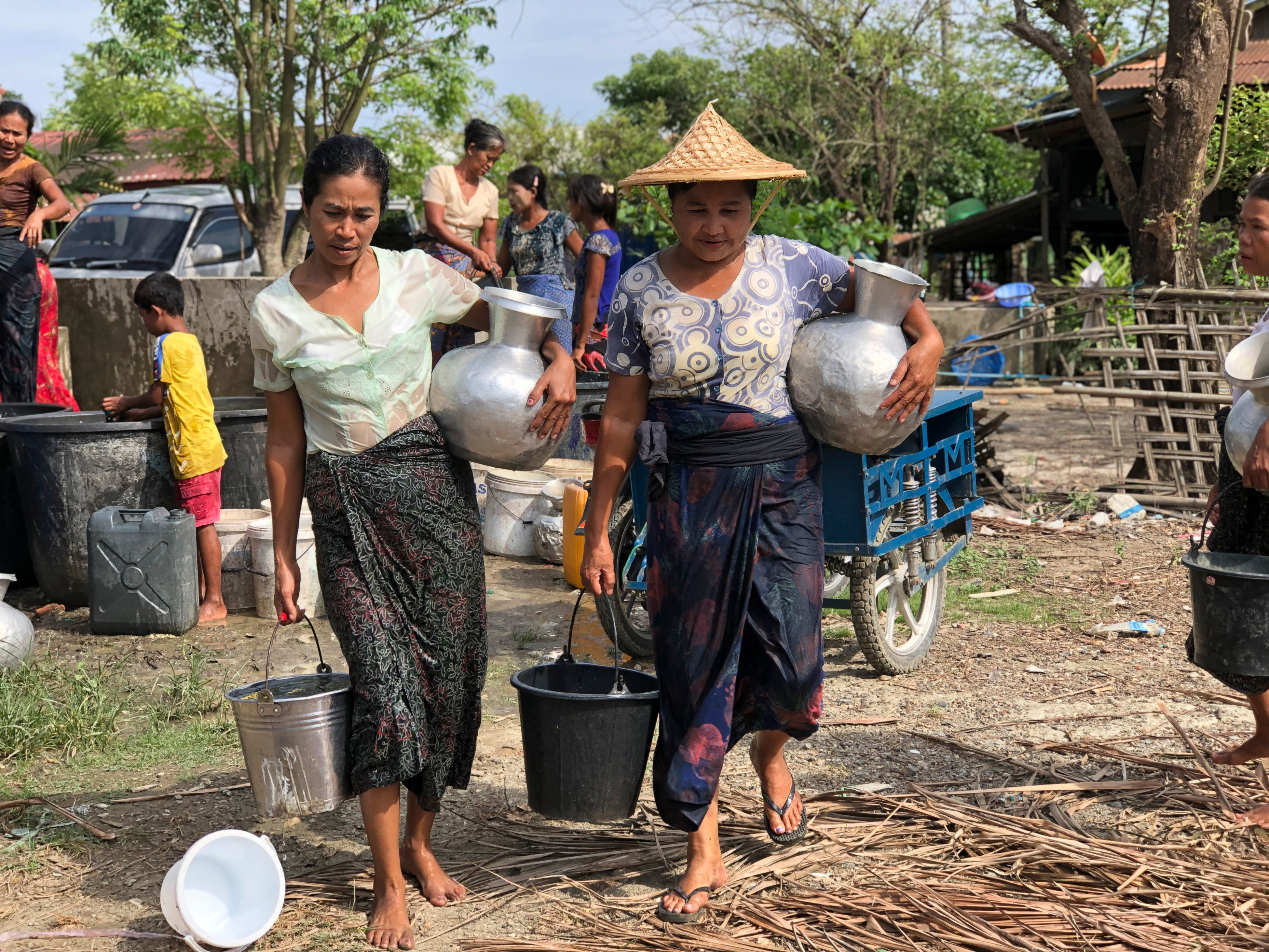 ミャンマー西部ラカイン州でバケツいっぱいの水を運ぶ女性たち。毎年乾季に問題になる水不足は、多くの住民の悩みの種になっている　©ICRC