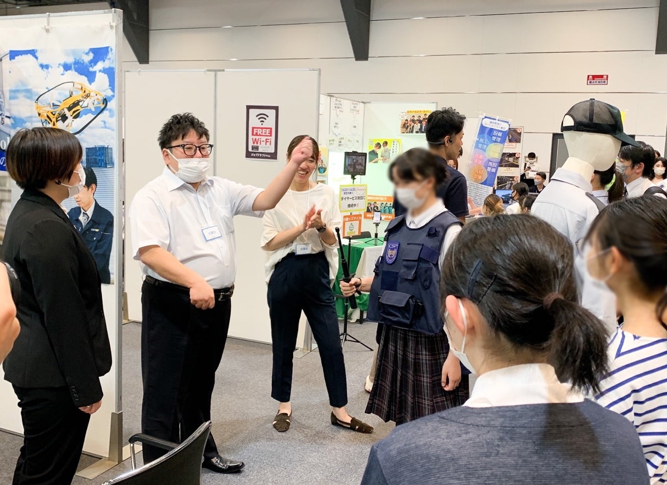 ▲警備の体験に集まる様子。警棒と防護服に触れます