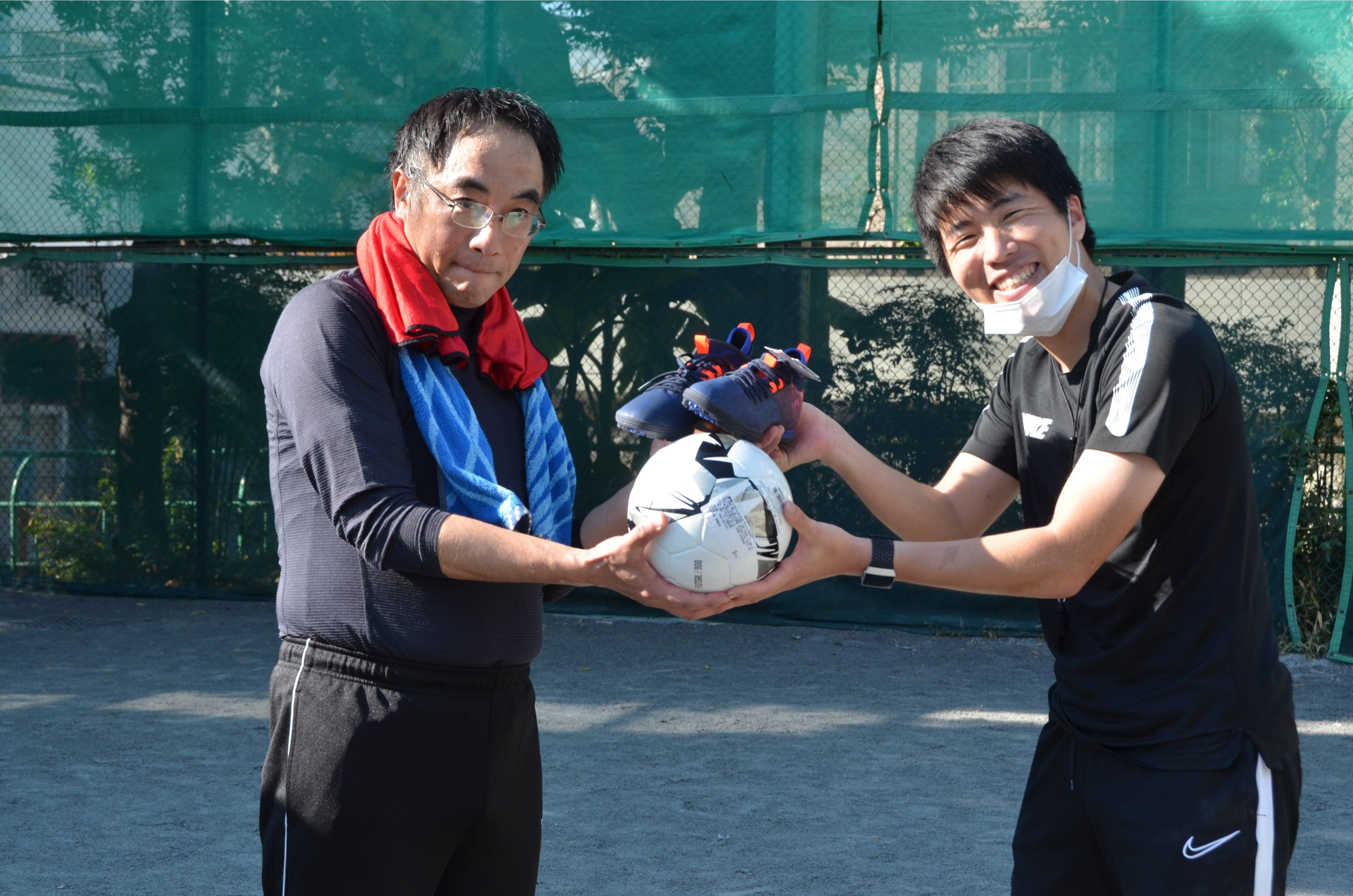 サッカー用品が手渡される様子（写真撮影時のみマスクを外しています）