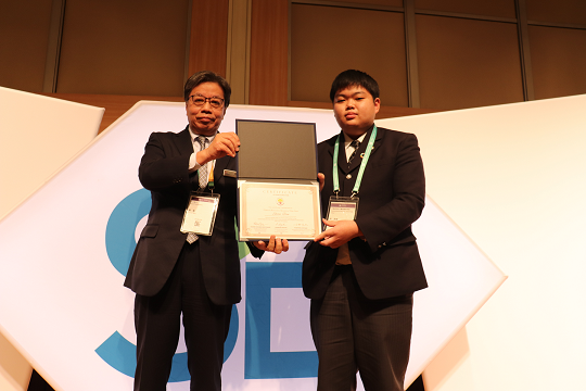 ▲当社役員から代表して参加証を受け取る北海道岩見沢農業高等学校の伴(ばん) 思穏(しおん)さん