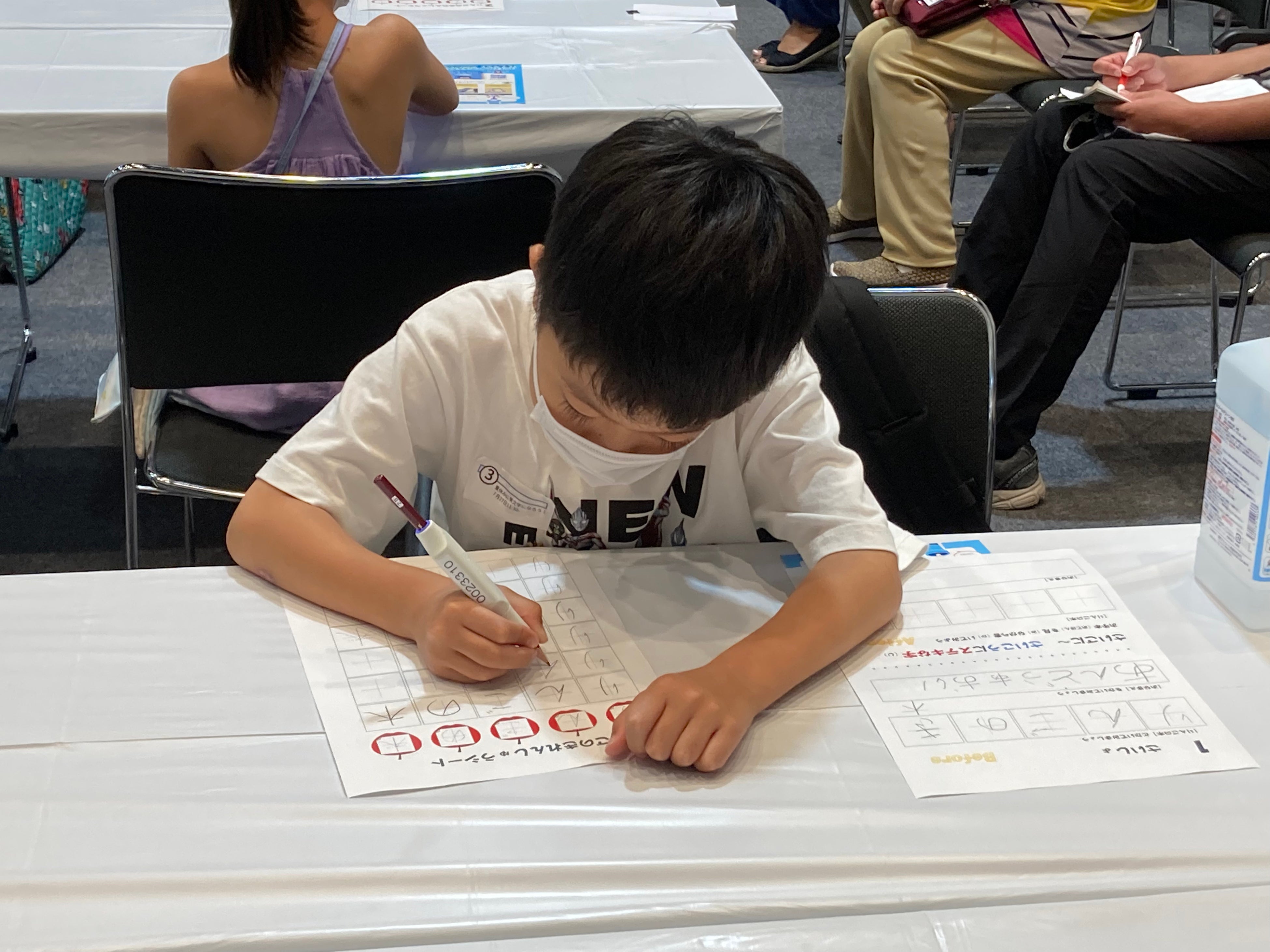 教わったとおりに美文字に挑戦する子ども達 しゅくだいやる気ペンのLEDの色の変化を楽しみながら、教わったとおりに「リンゴの木」を書く子どもの姿